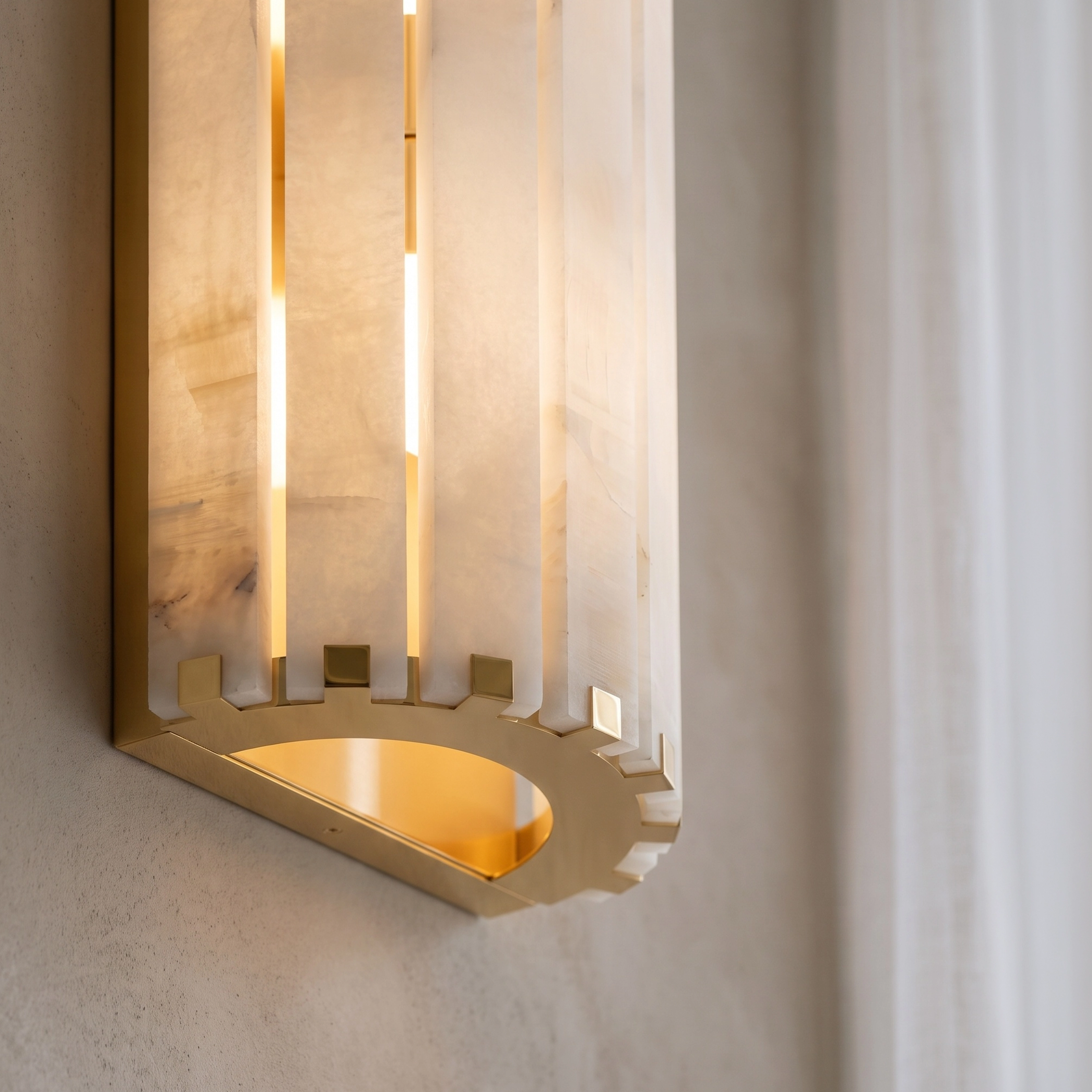 Nala alabaster bar wall sconce glowing warm white on a stone bathroom wall