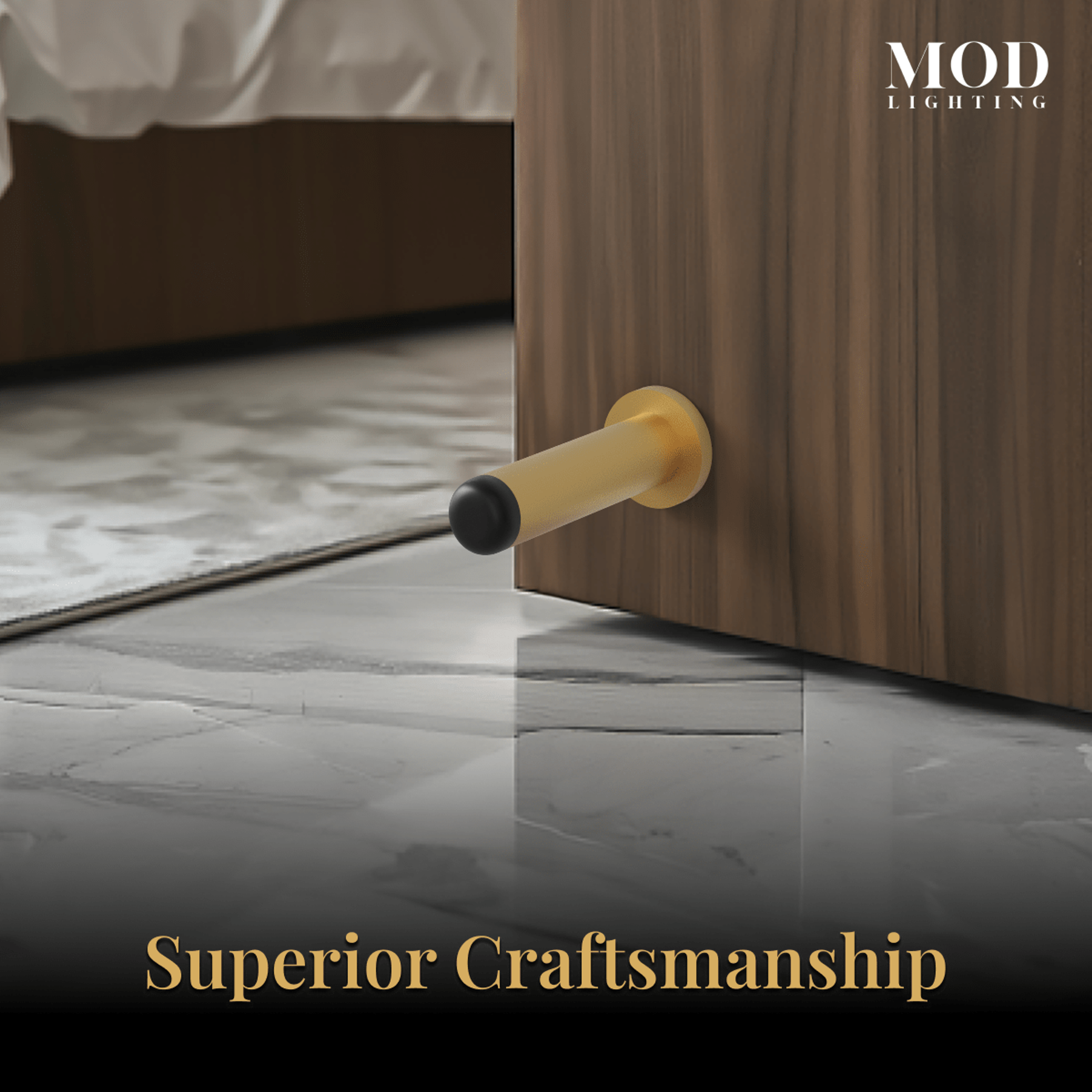 Aro brushed-gold cylindrical wall door stop with black rubber tip cushioning a door