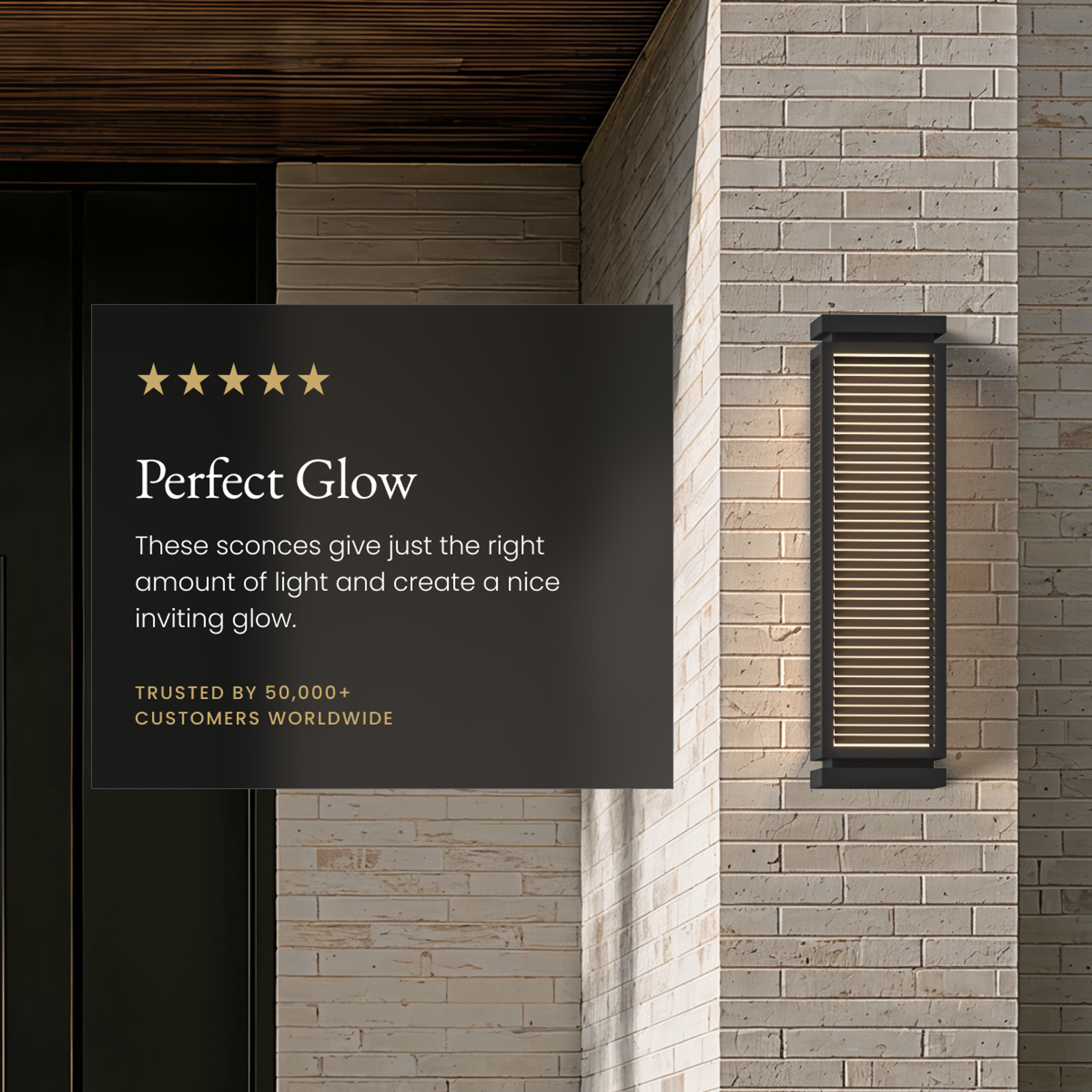 Fern black louvered outdoor sconce glowing on a brick wall beside a five-star review card