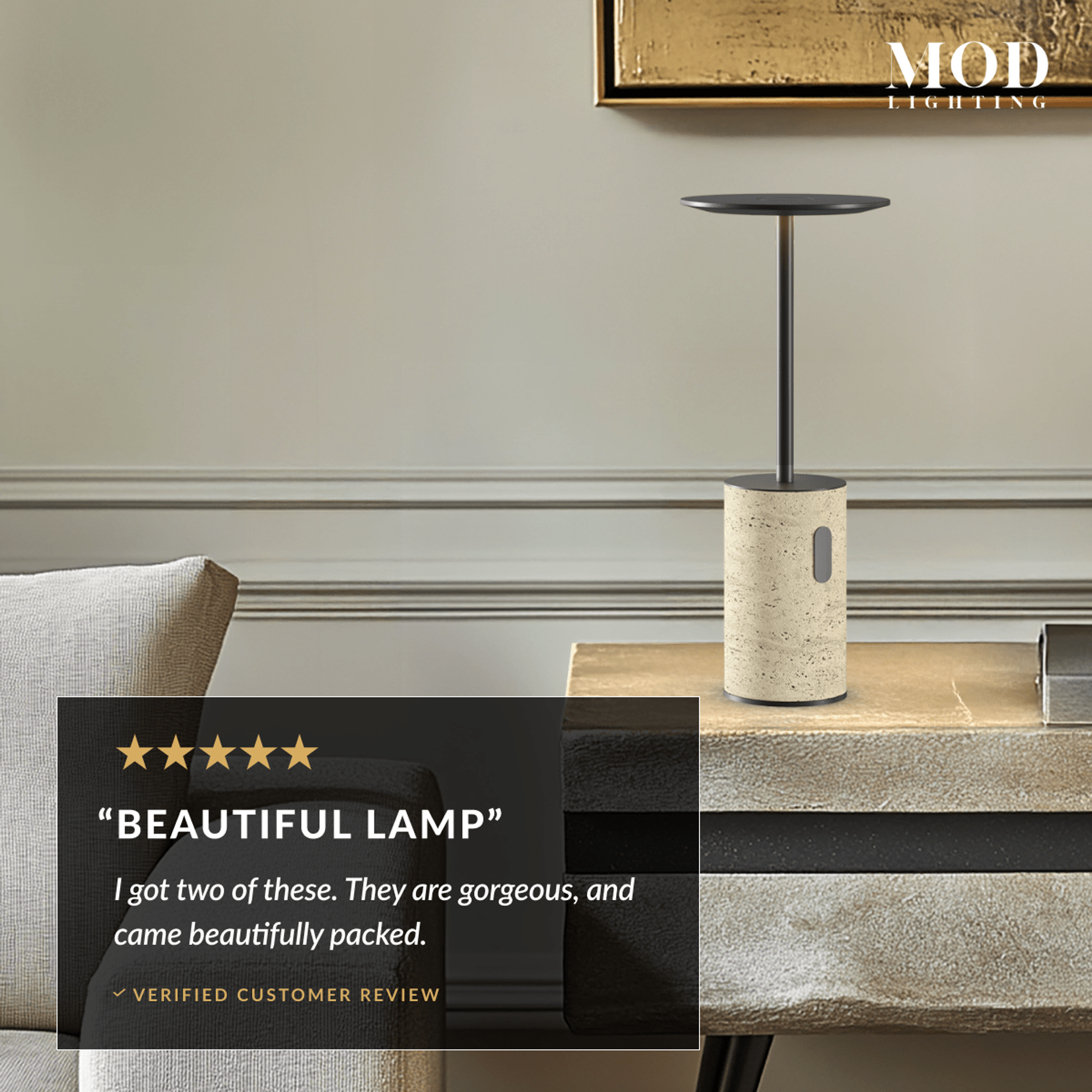Vera table lamp with travertine base and black disc shade on a console beside a bed, glowing warm white