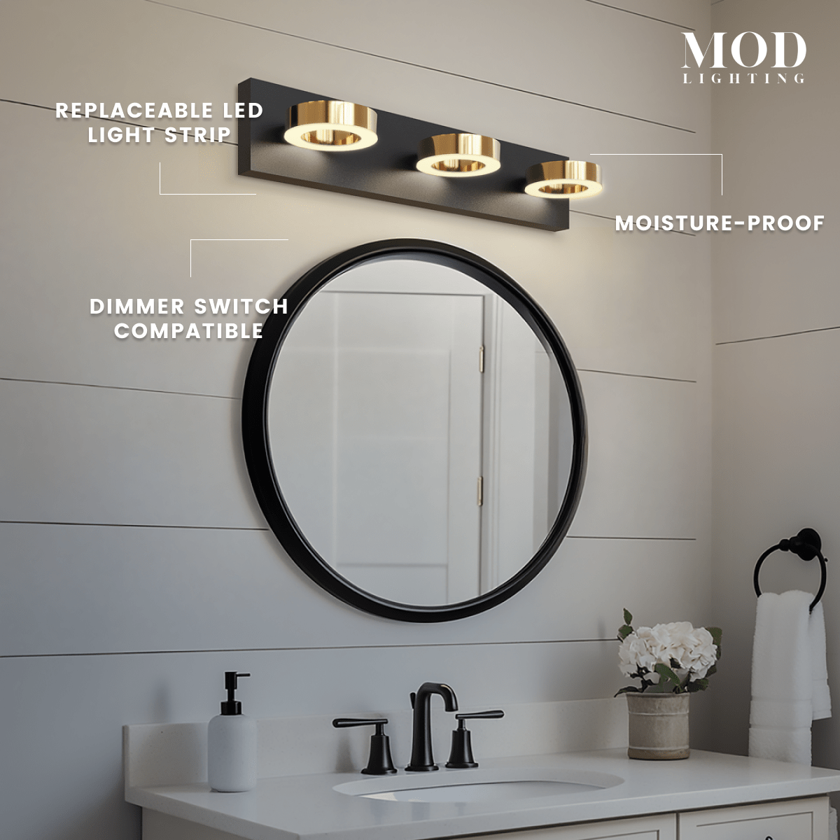 Aurora three-light black vanity bar with gold rings above a round mirror, noting moisture-proof, dimmer-compatible LED strip