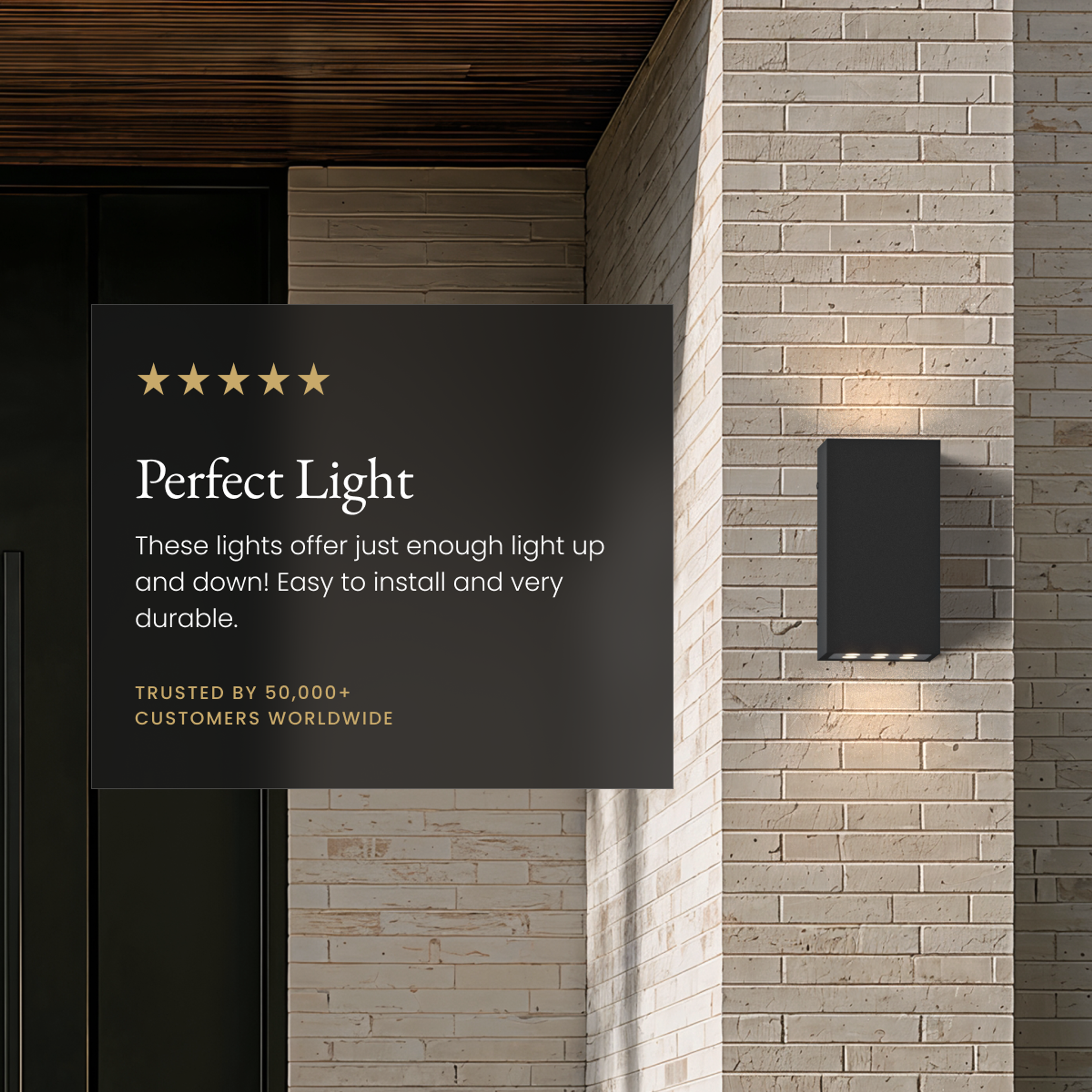 Harlow black up-down outdoor sconce casting light on a brick wall beside a five-star review card