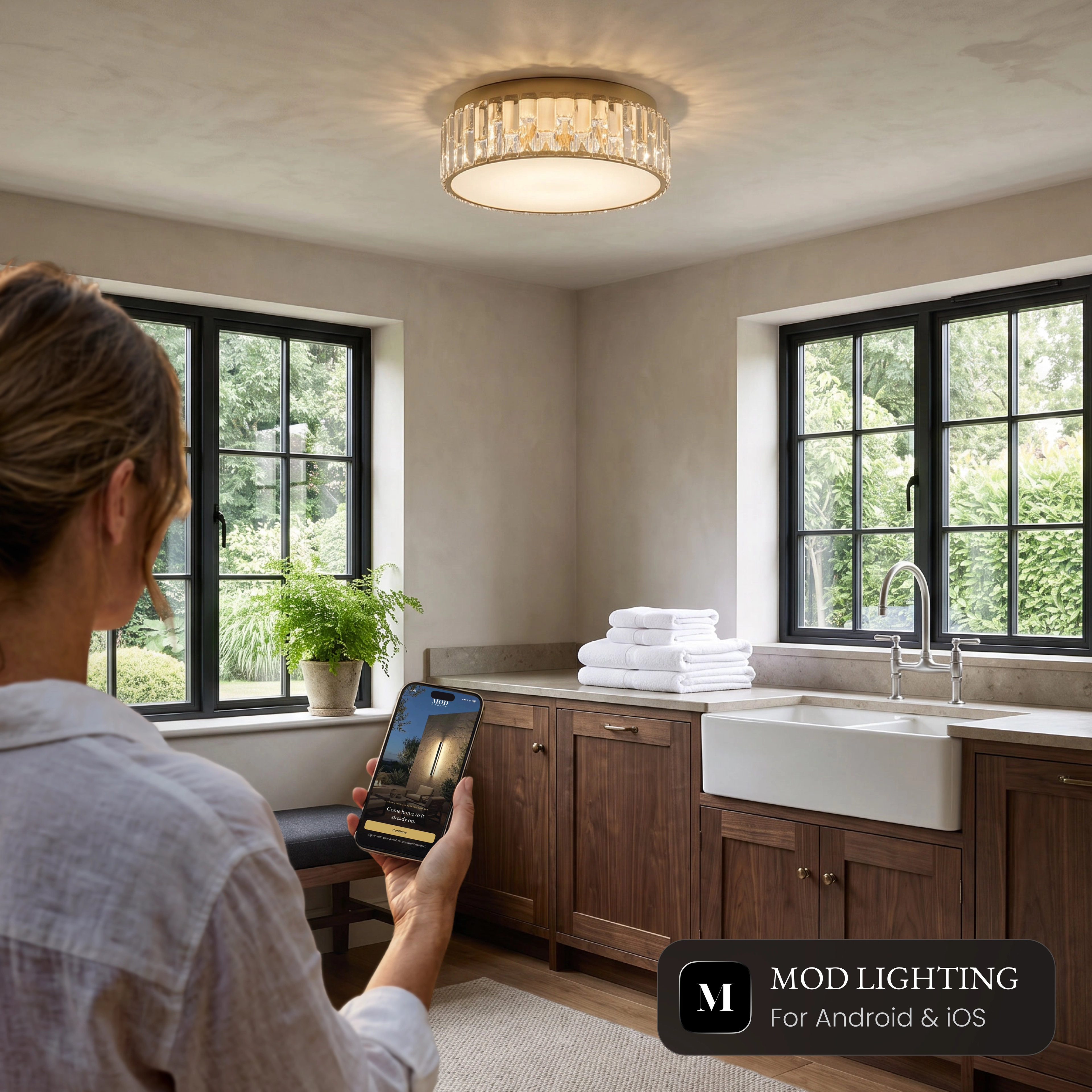 Elara Smart crystal flush mount ceiling light in a kitchen, controlled from the MOD LIGHTING app on a phone