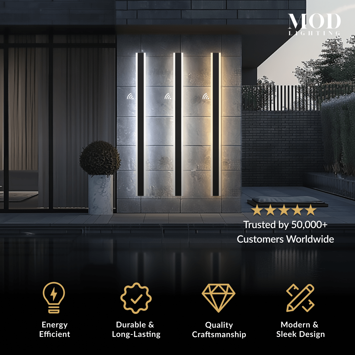 Haylen wall lights, tall slim black LED bars lit vertically on a stone facade at night