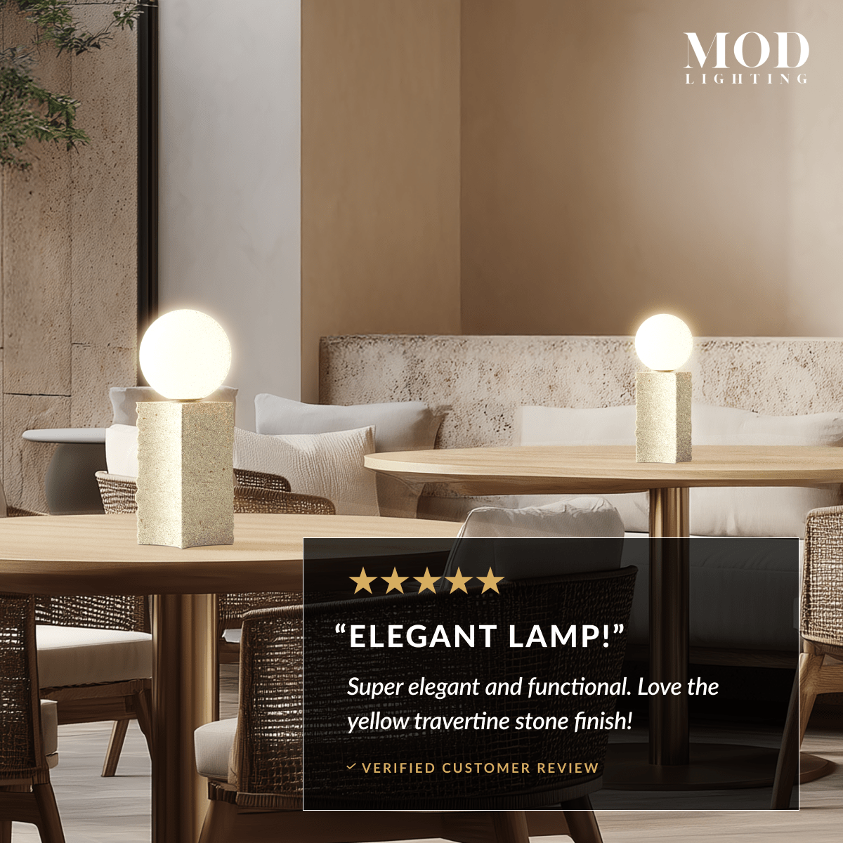 Arabella cream travertine stone table lamp, rectangular column base with white glass globe, lit on a dining table