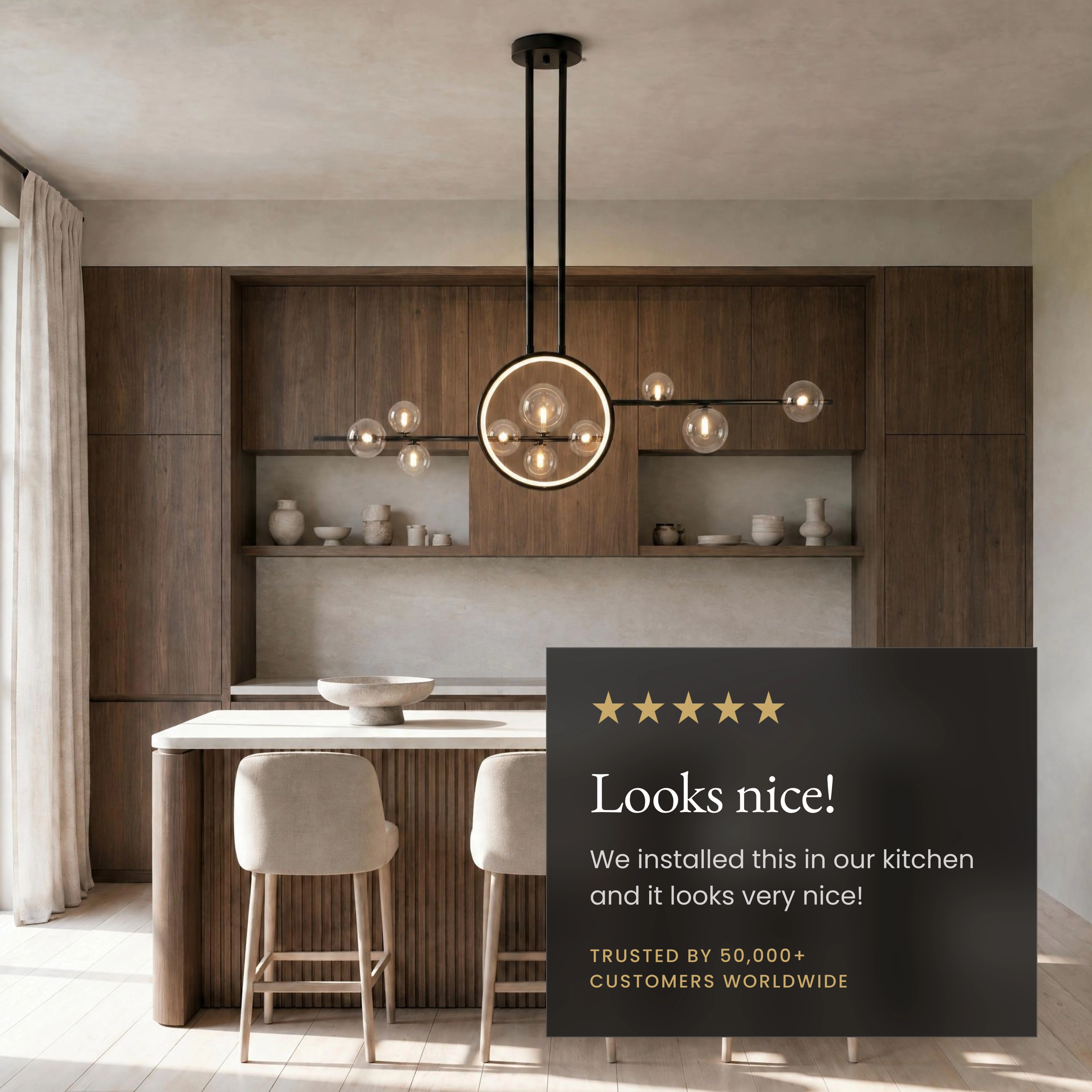 Hailey Nordic chandelier, black linear bar with gold rings and clear glass orbs, over a kitchen island