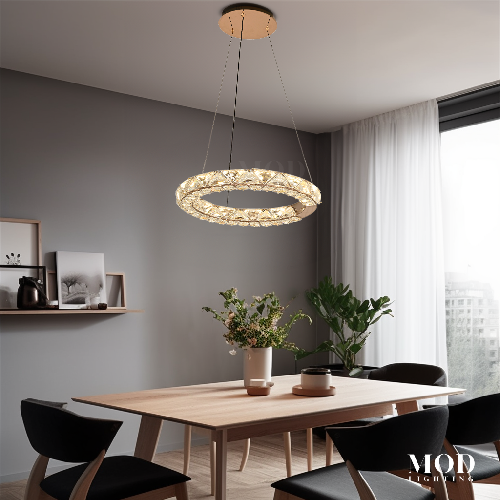 Jana, single gold crystal-studded LED ring pendant hung over a wood dining table
