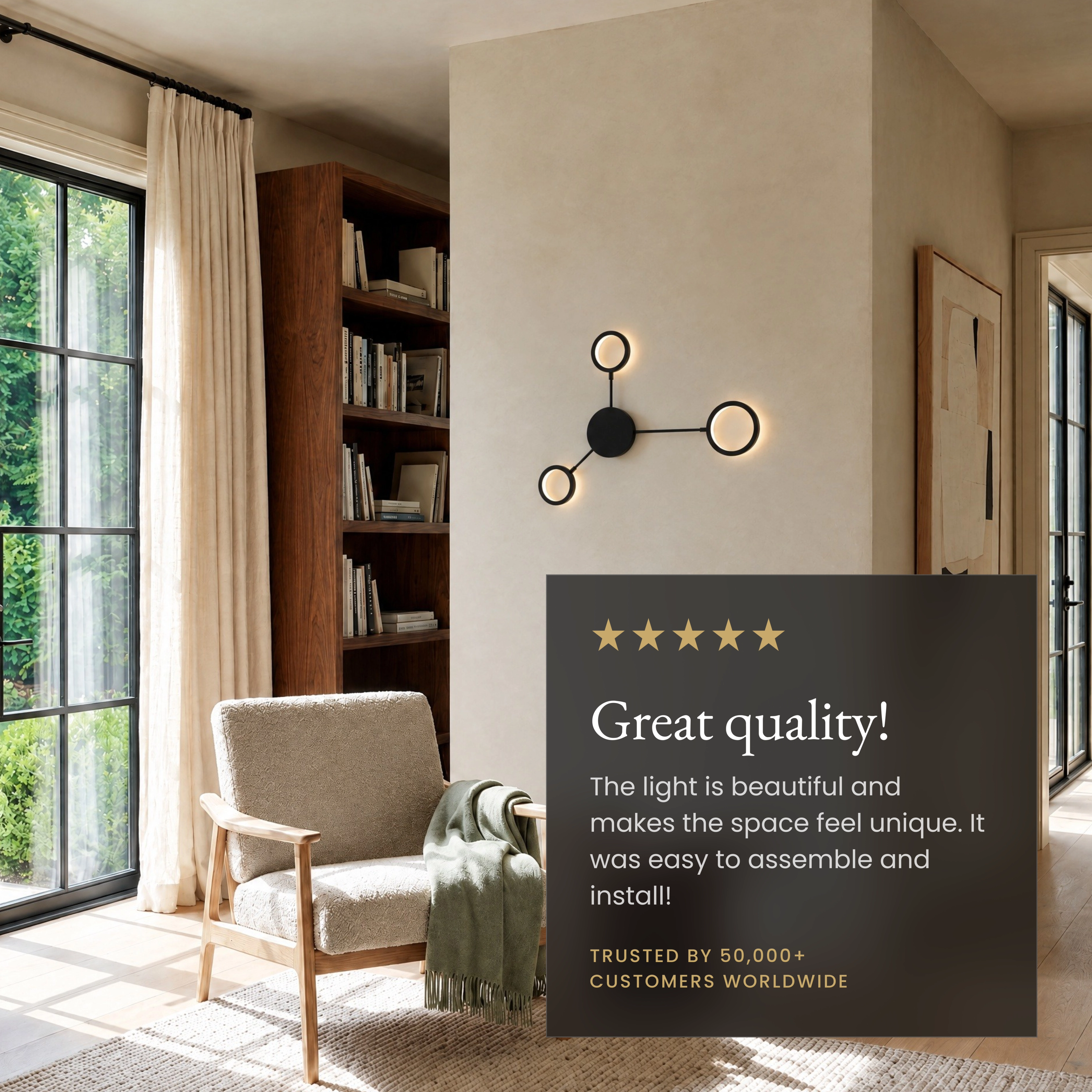 Link wall light, black rods linking circular gold discs, mounted on a wall beside a curved chair