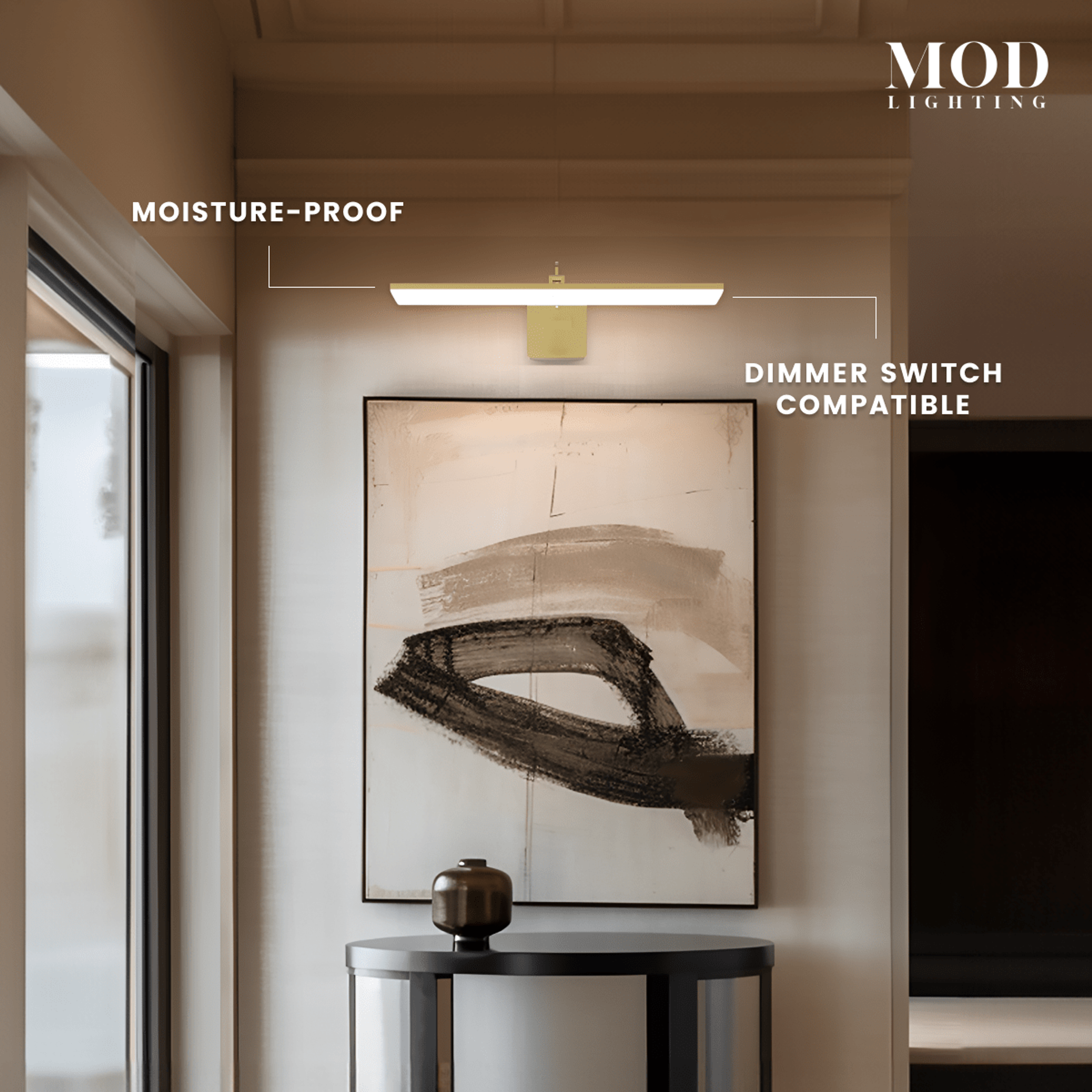 Zena slim brushed-gold horizontal bar light glowing above framed art in a hallway, moisture-proof and dimmer-compatible