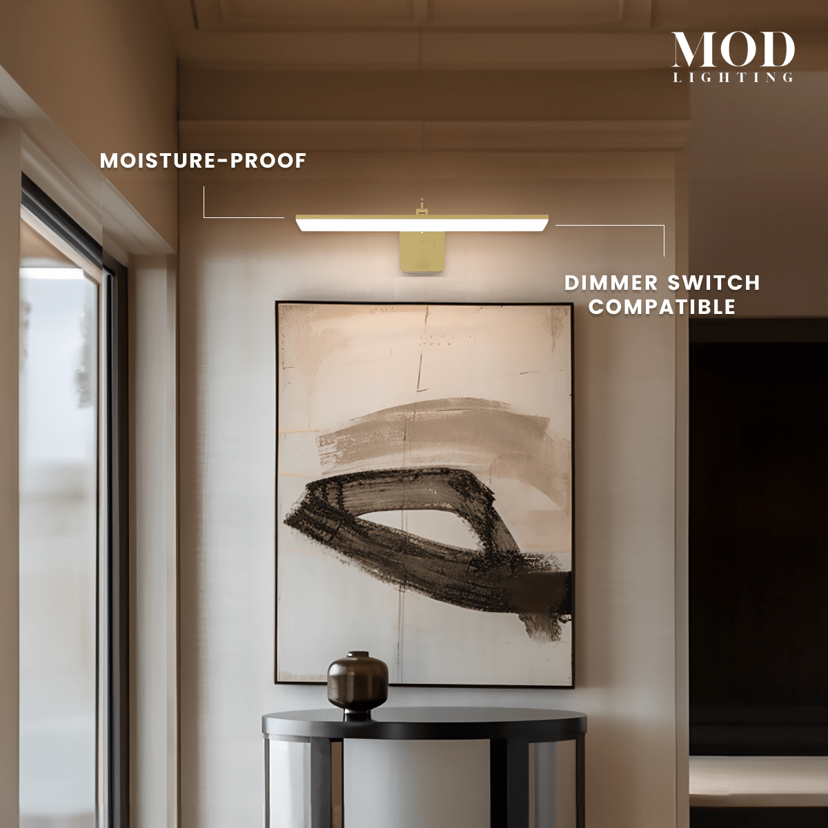 Zena slim brushed-gold horizontal bar light glowing above framed art in a hallway, moisture-proof and dimmer-compatible