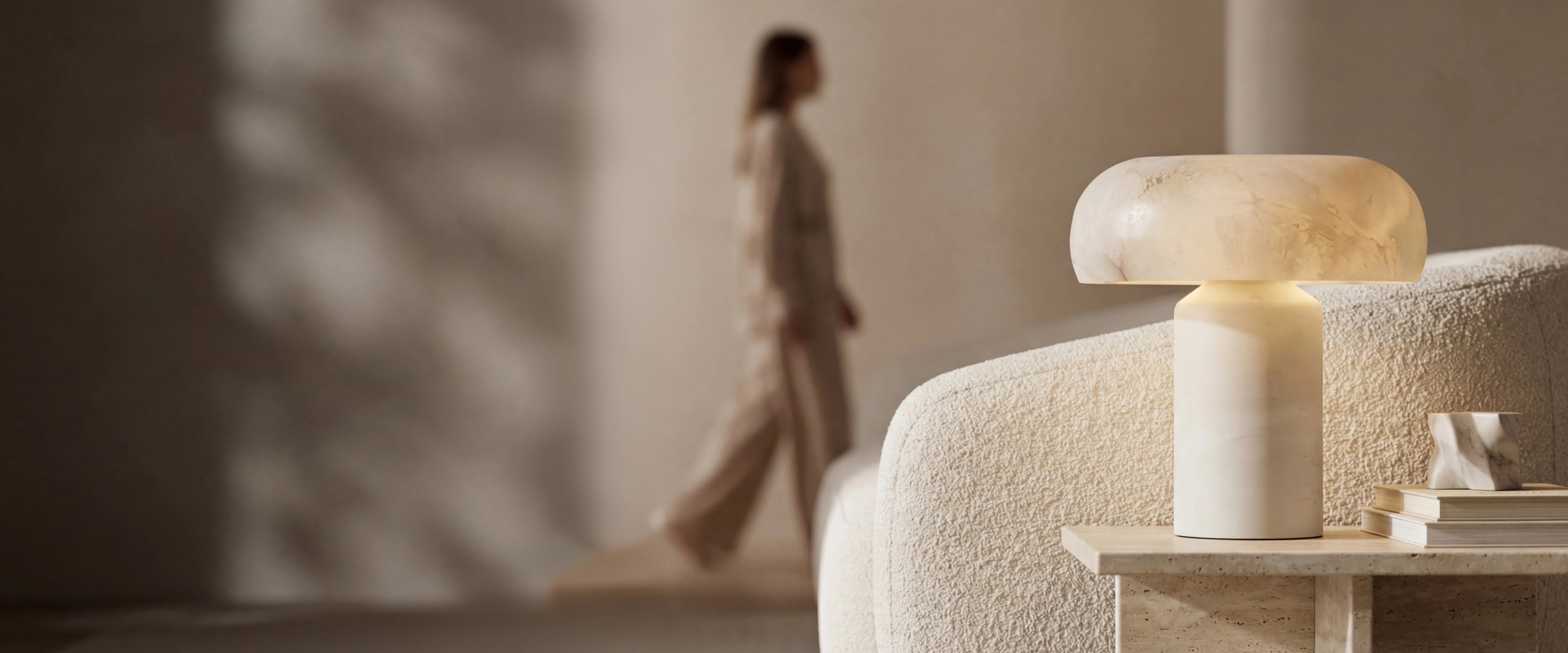 MOD LIGHTING alabaster table lamp on a travertine side table in a warm modern living room
