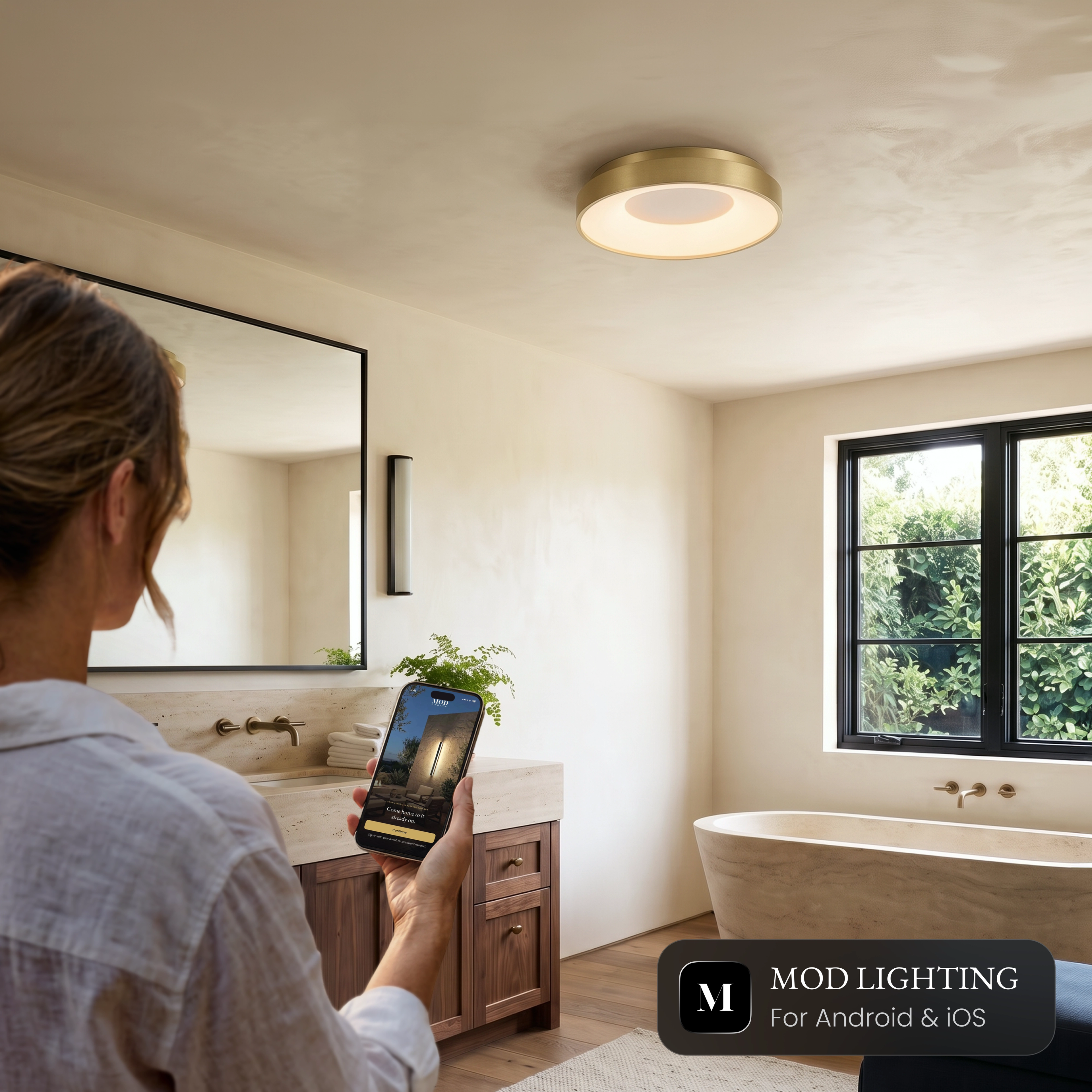 Woman controlling the Bryce Smart ceiling light from the MOD Smart Home app on her phone