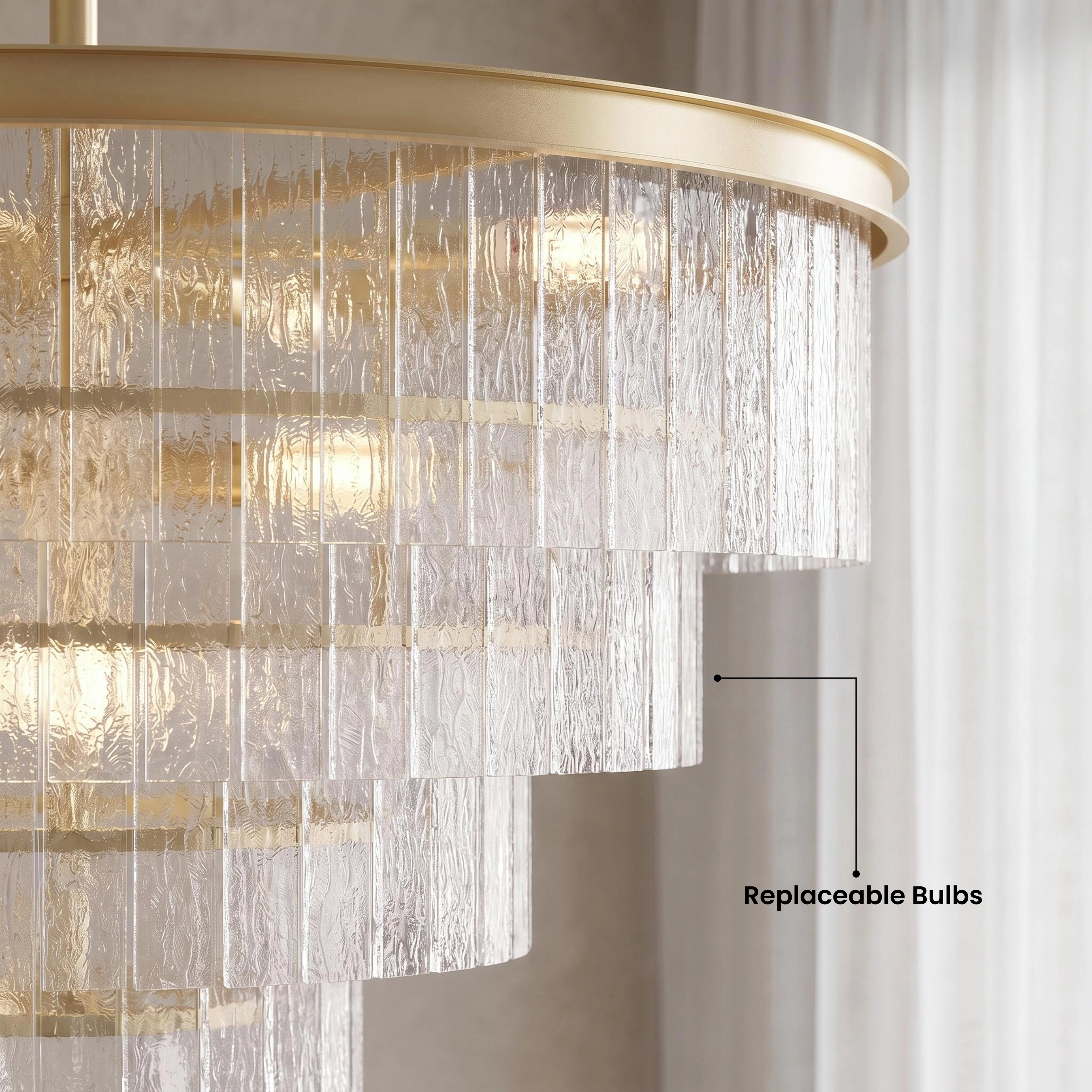 Cascade brass chandelier with tiered textured-glass fringe over a dining table, warm-white glow