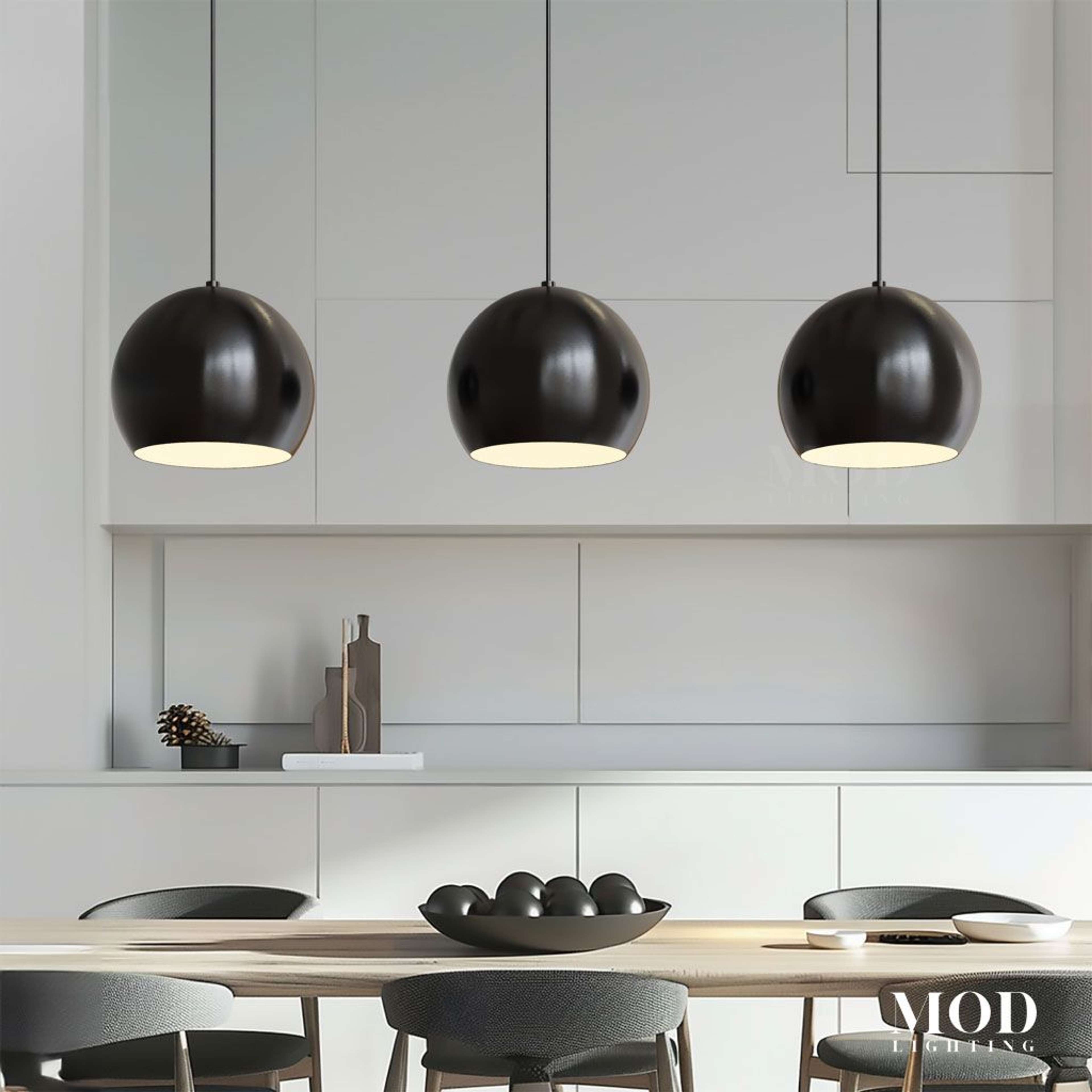 Avery, row of three black spherical dome pendants over a counter in a white kitchen