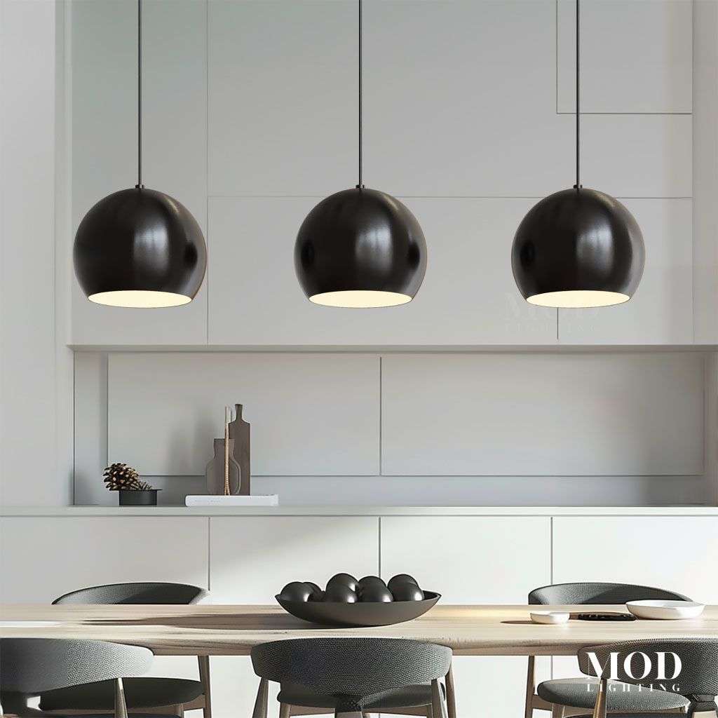 Avery, row of three black spherical dome pendants over a counter in a white kitchen