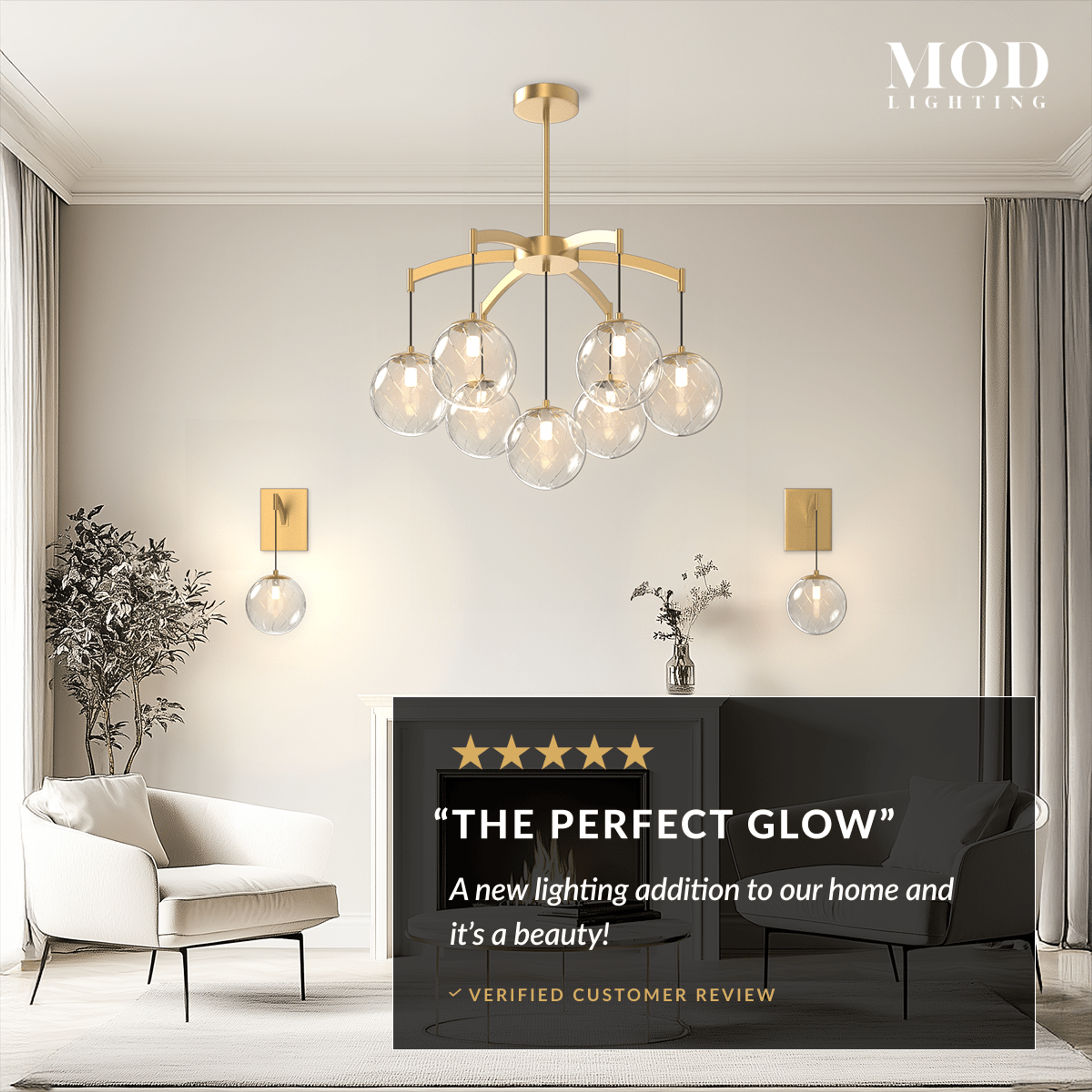 Mirella brushed-gold chandelier with tiered amber glass globes glowing over a neutral living room with a fireplace