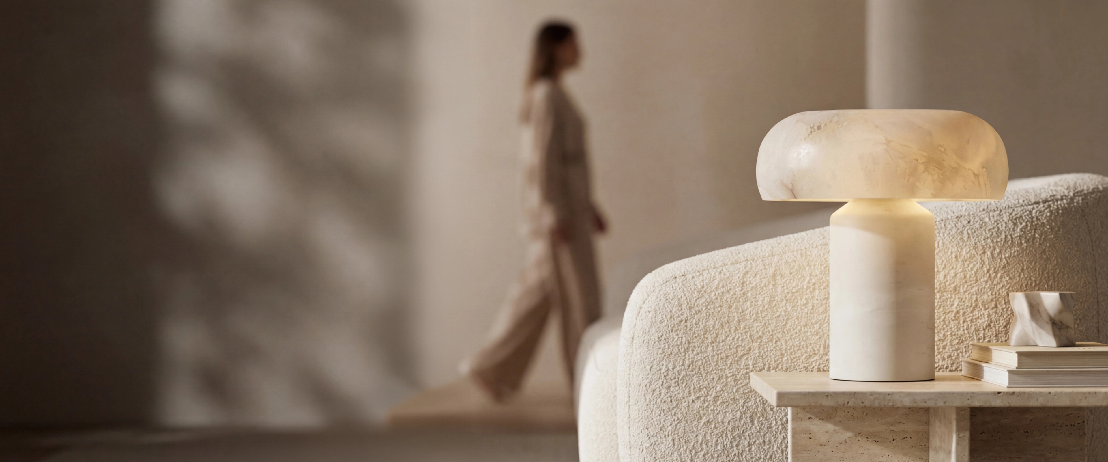 MOD LIGHTING alabaster table lamp on a travertine side table in a warm modern living room
