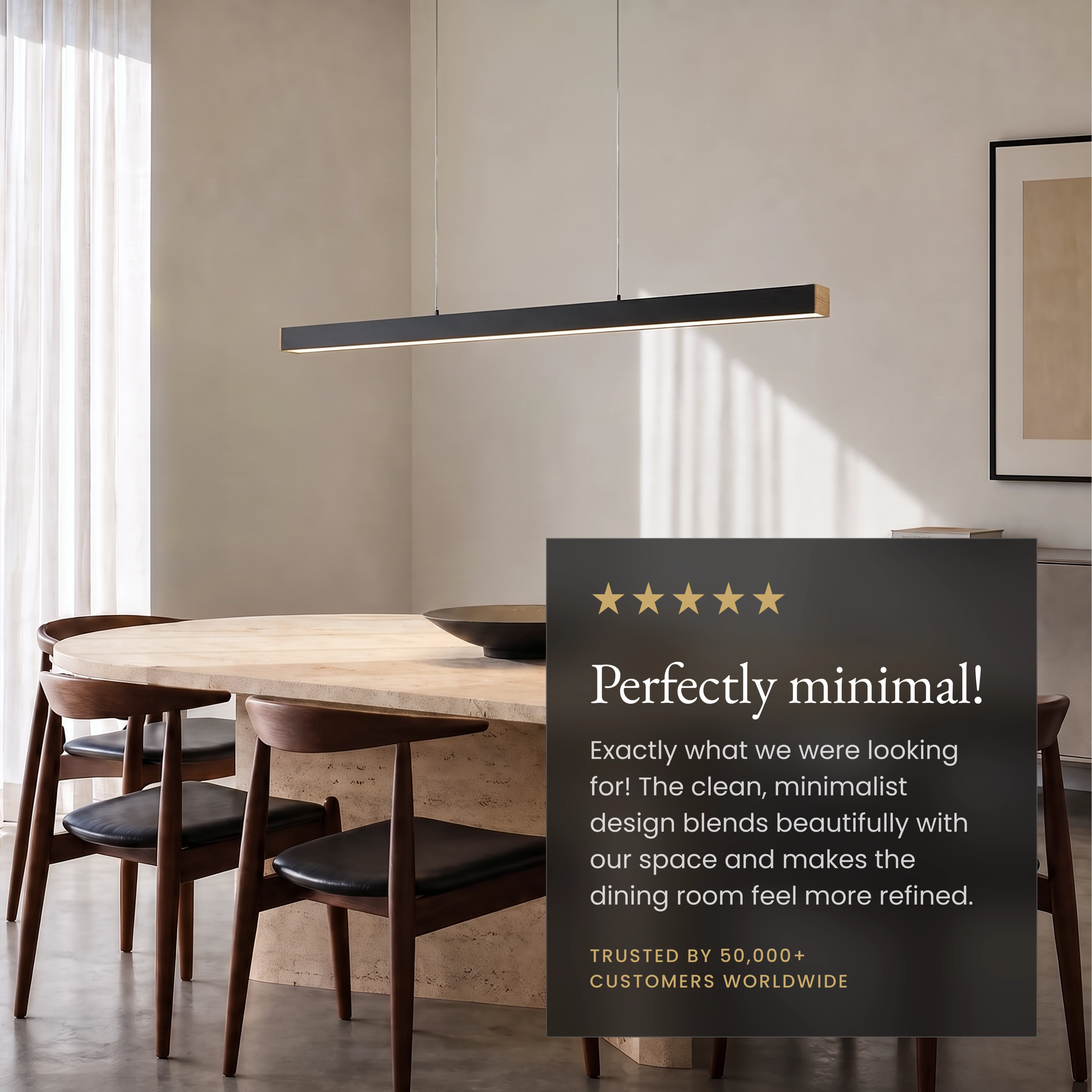 Luka pendant, slim copper linear bar lit warm, suspended above a sofa in a grey living room