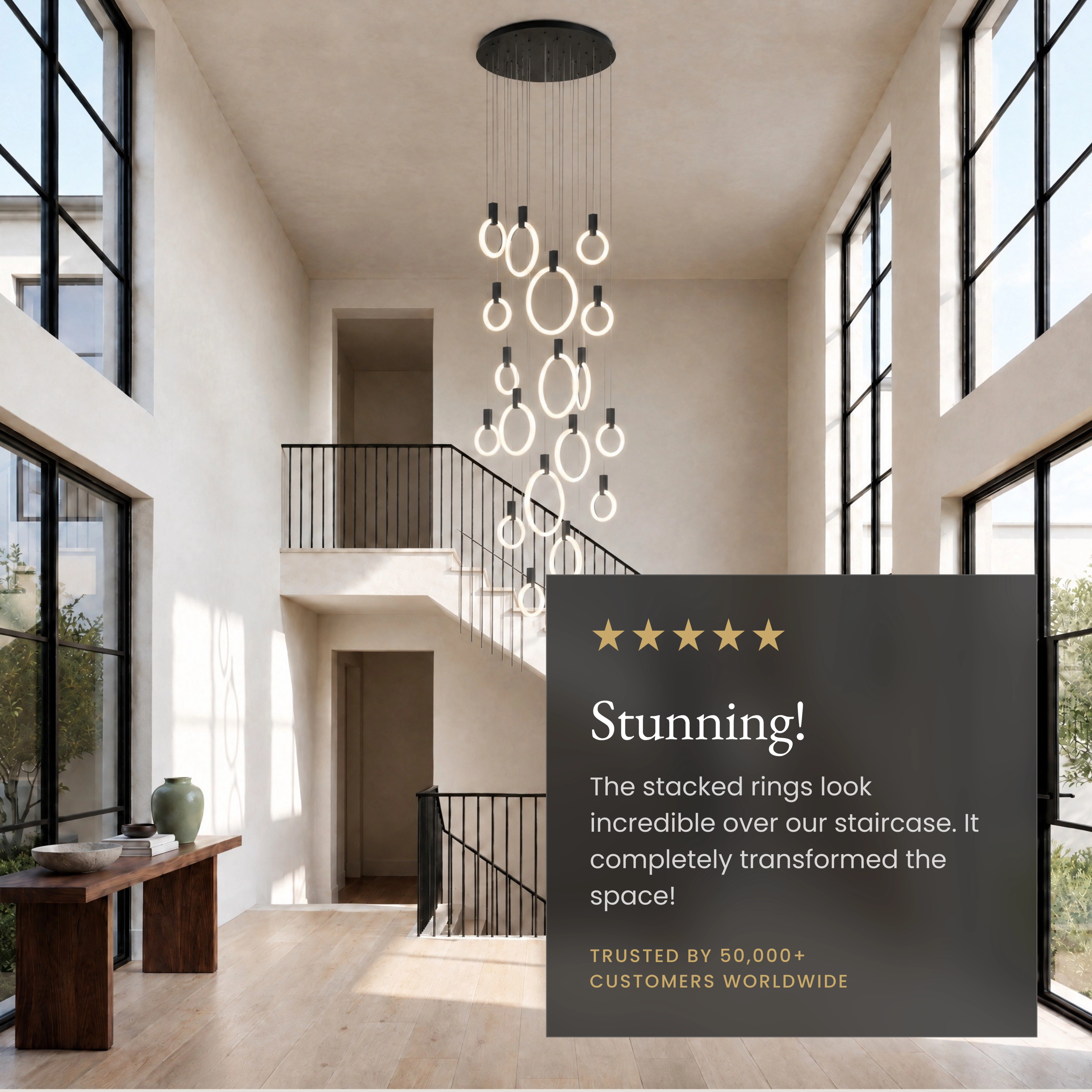 Skyla chandelier, cascading lit rings on black mounts, over a living room with green velvet chairs