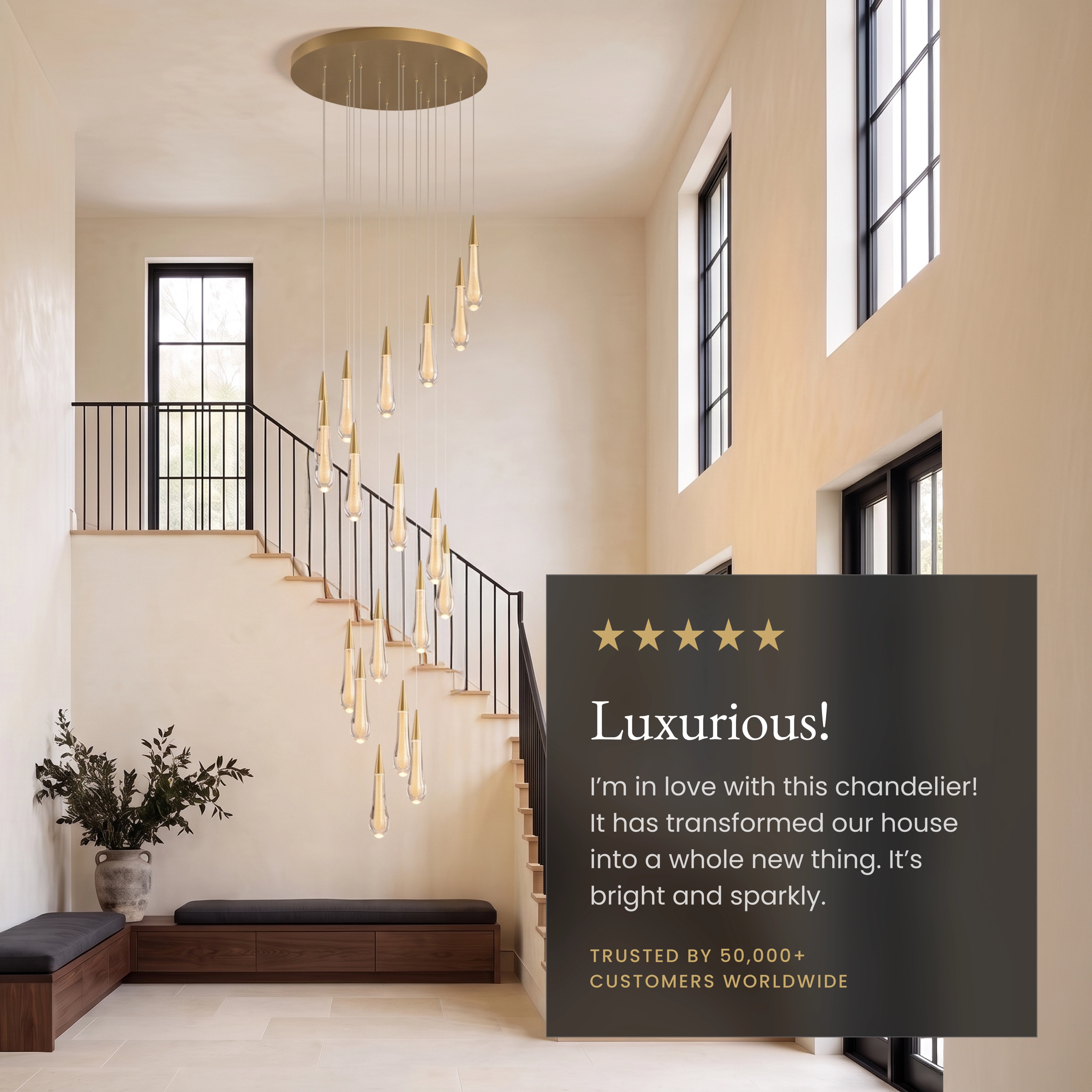 Indra chandelier, gold crystal teardrops cascading beside a curved staircase