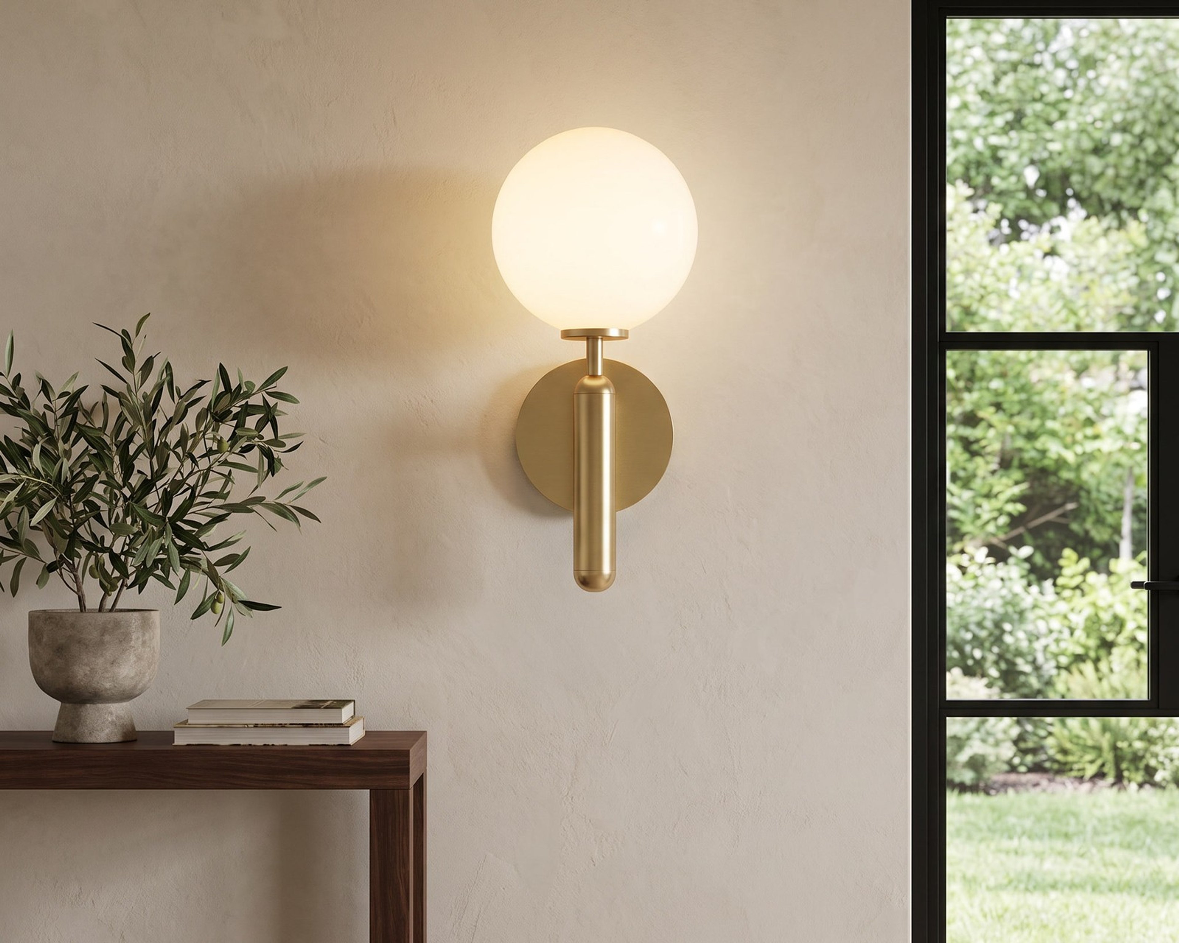 Brass globe wall sconce beside a window