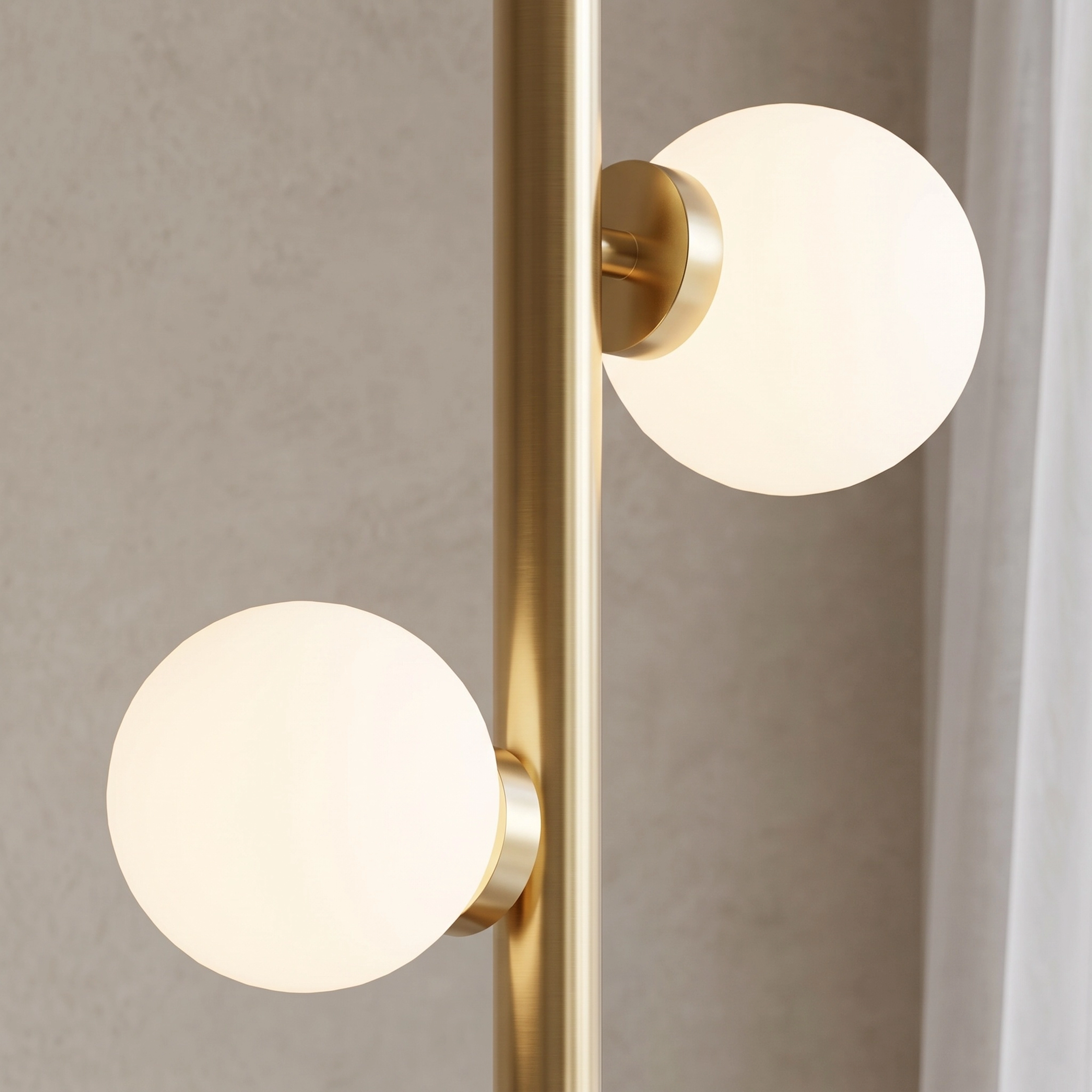 Pearl floor lamp in gold, warm white globes lit, standing on a wood floor in a neutral room