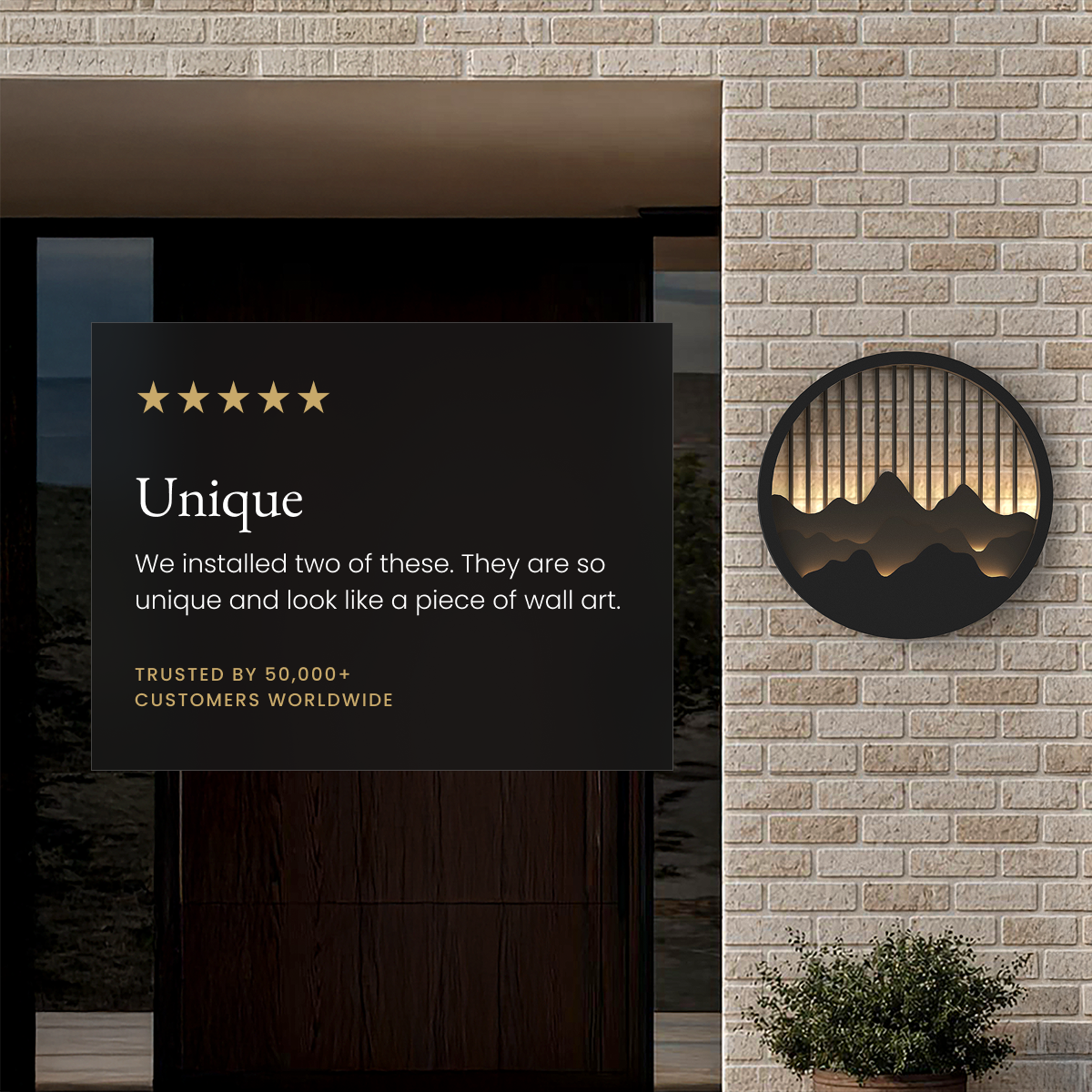 Valley black round mountain-silhouette wall light glowing on a brick exterior, beside a five-star customer review card