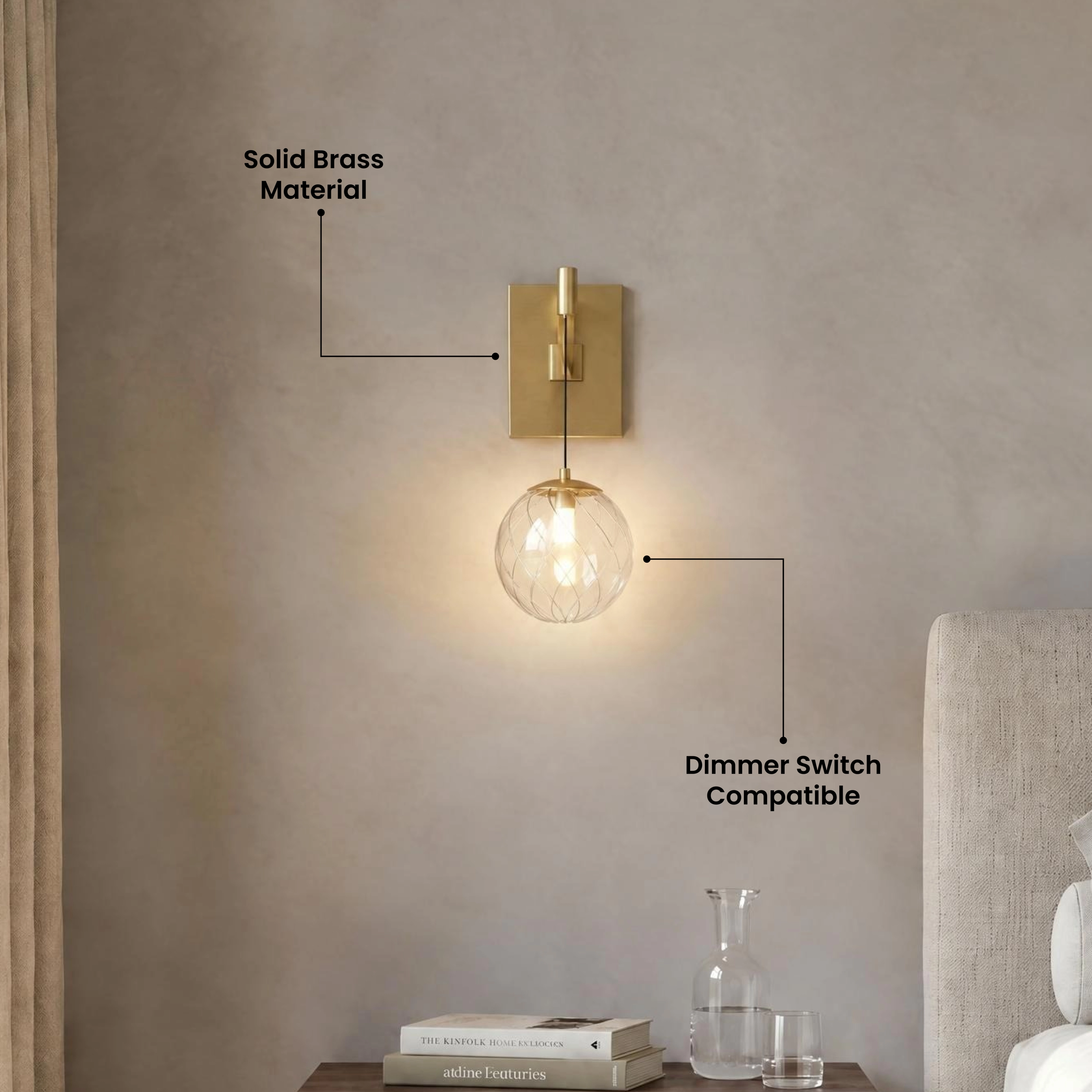 Mirella Sconce, brushed-gold arm and clear glass globe, mounted on a bright wall beside greenery