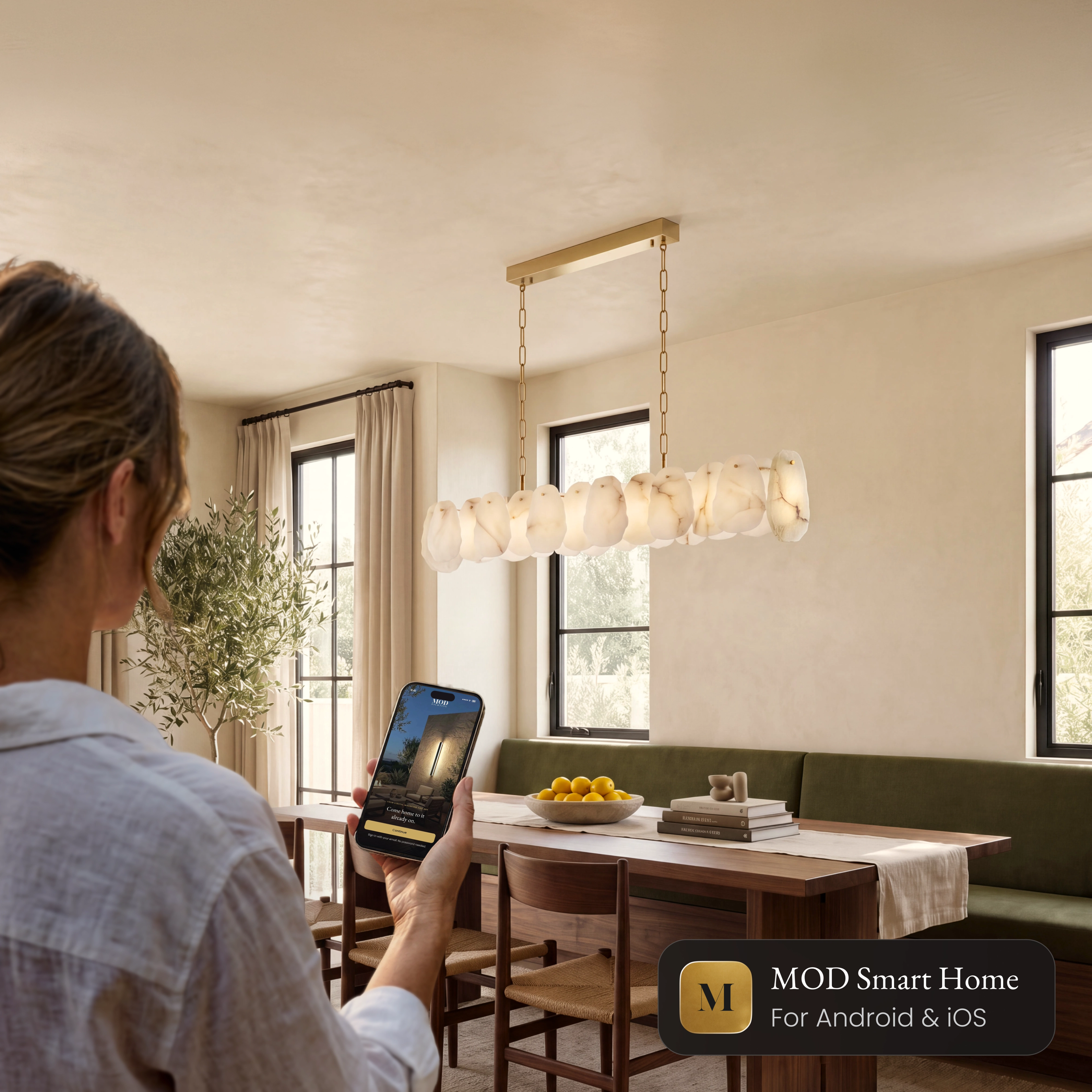 Alba Pendant Smart linear alabaster pendant over a dining table, controlled from the MOD Smart Home app on a phone