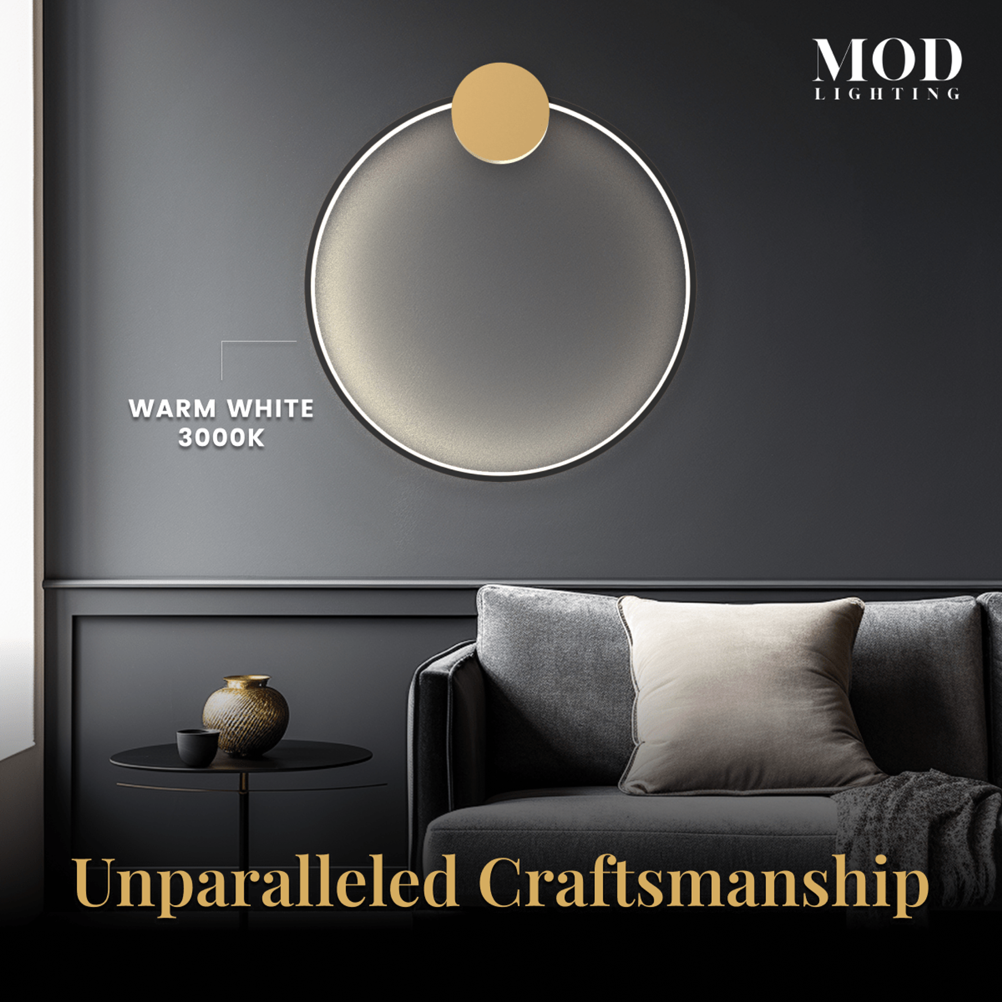 Halo wall lamp, gold ring lit warm white against a dark wall above a grey sofa in a living room