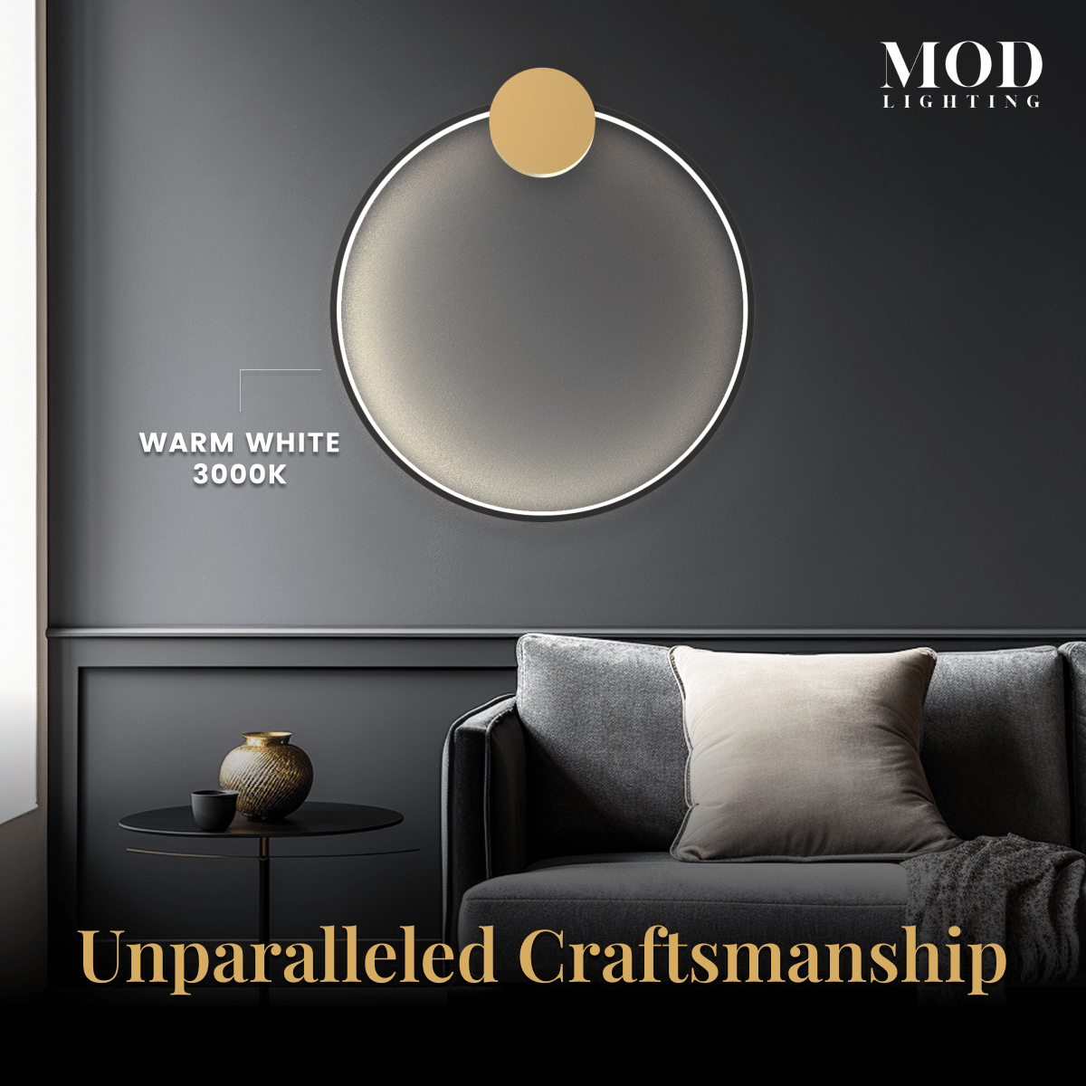 Halo wall lamp, gold ring lit warm white against a dark wall above a grey sofa in a living room