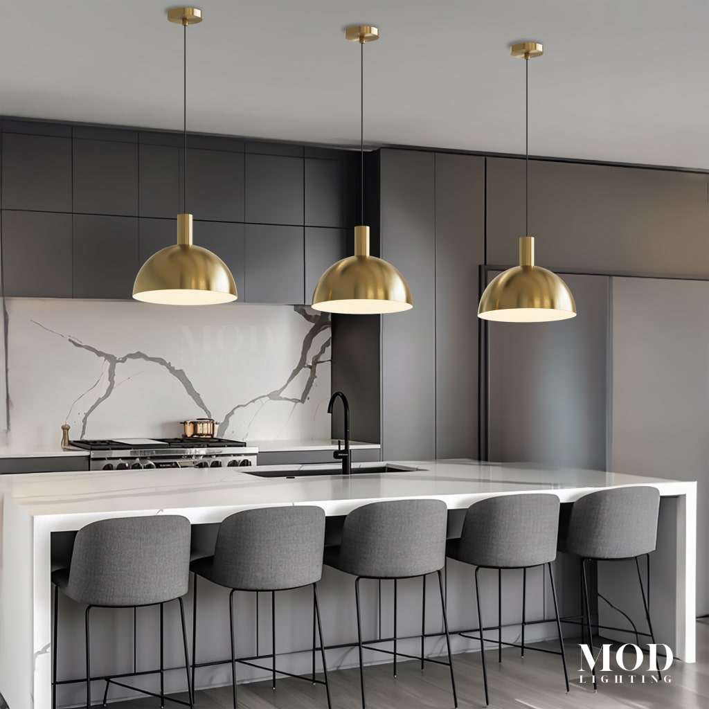 Kinsley brushed-gold dome pendants, three hanging over a marble kitchen island with grey bar stools