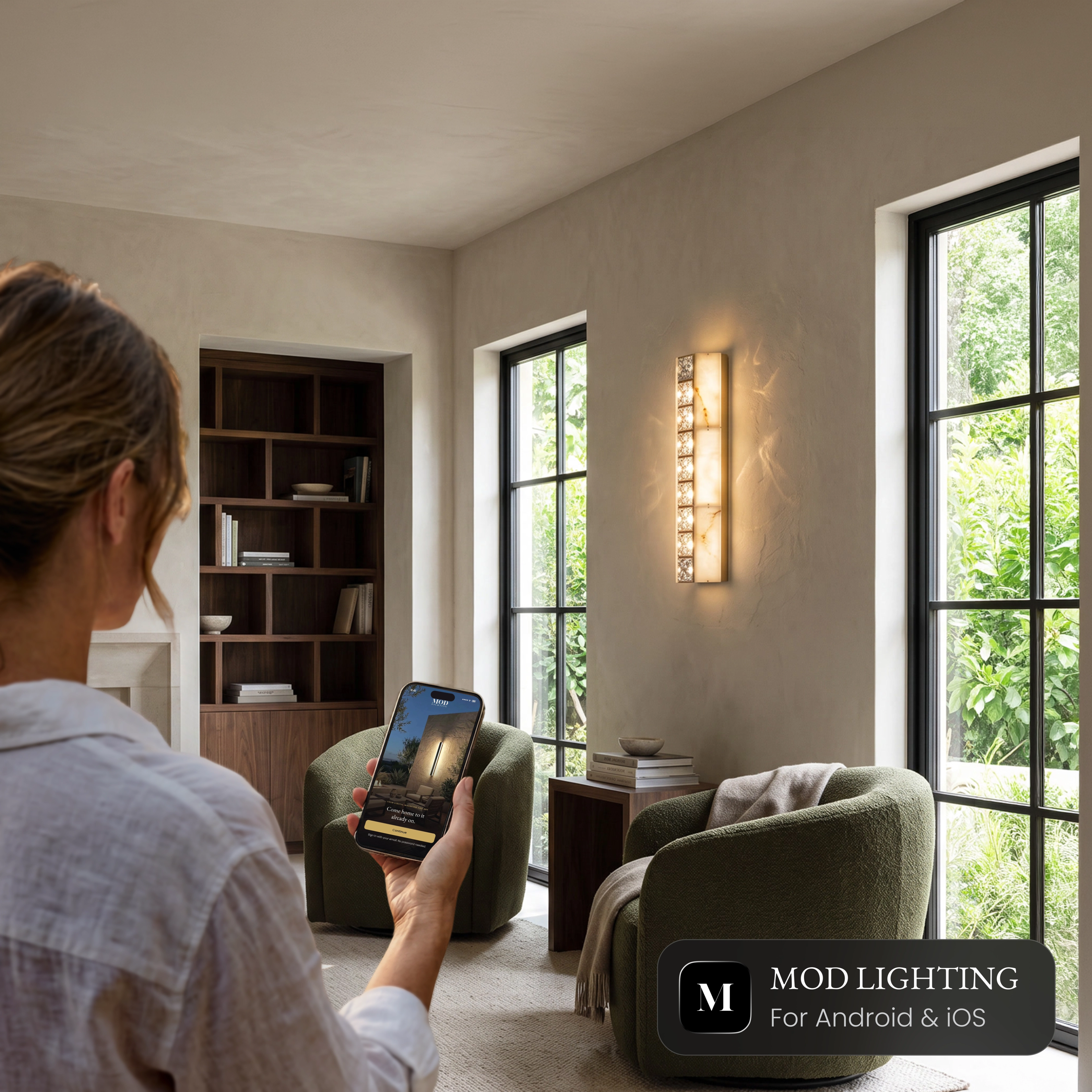 Seraphine Sconce Smart crystal wall sconce in a living room, controlled from the MOD LIGHTING app on a phone