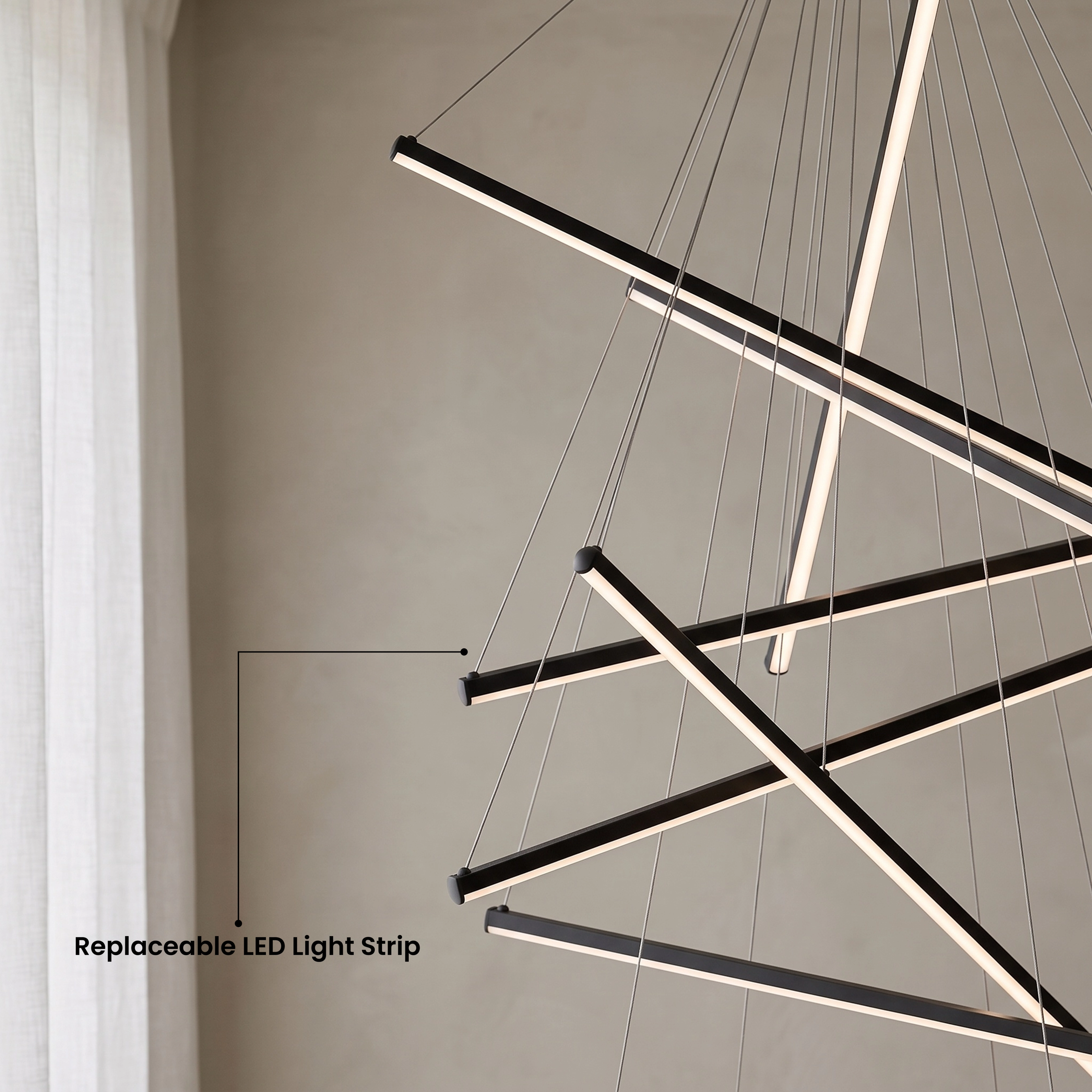 Finn black cascading light bars in warm white 3000K over a chair, available in four sizes