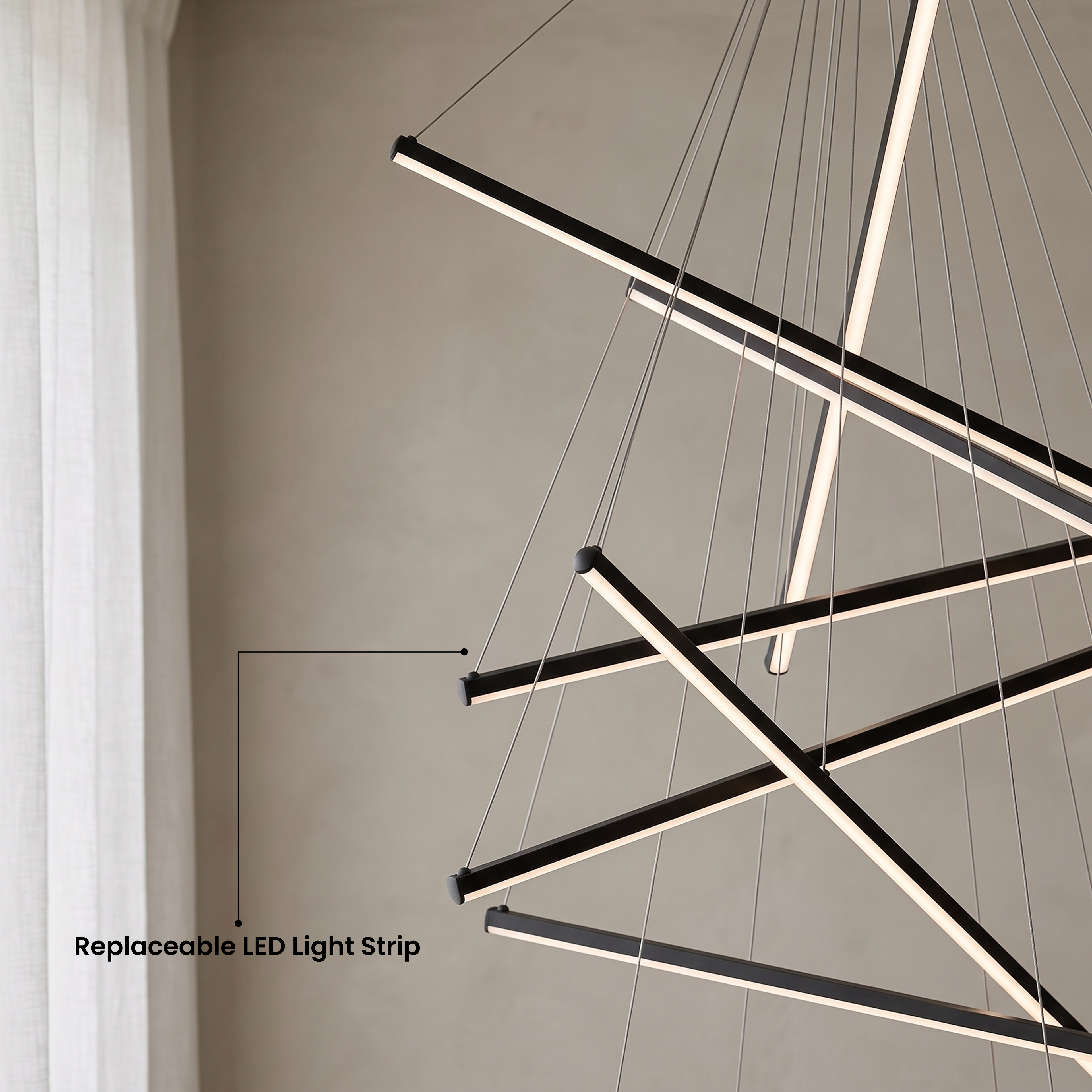 Finn black cascading light bars in warm white 3000K over a chair, available in four sizes