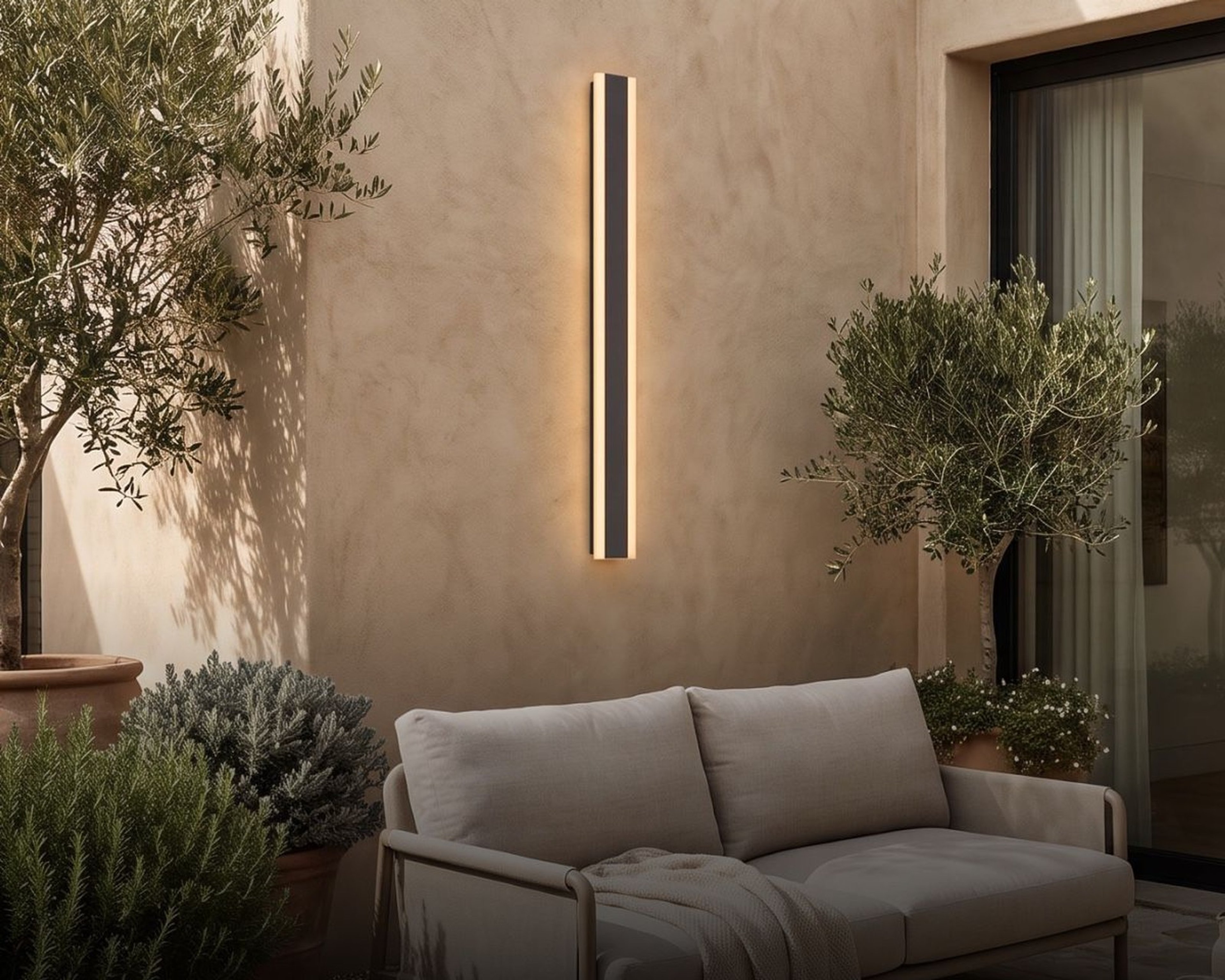 Harper outdoor wall light on a terrace wall above a garden sofa