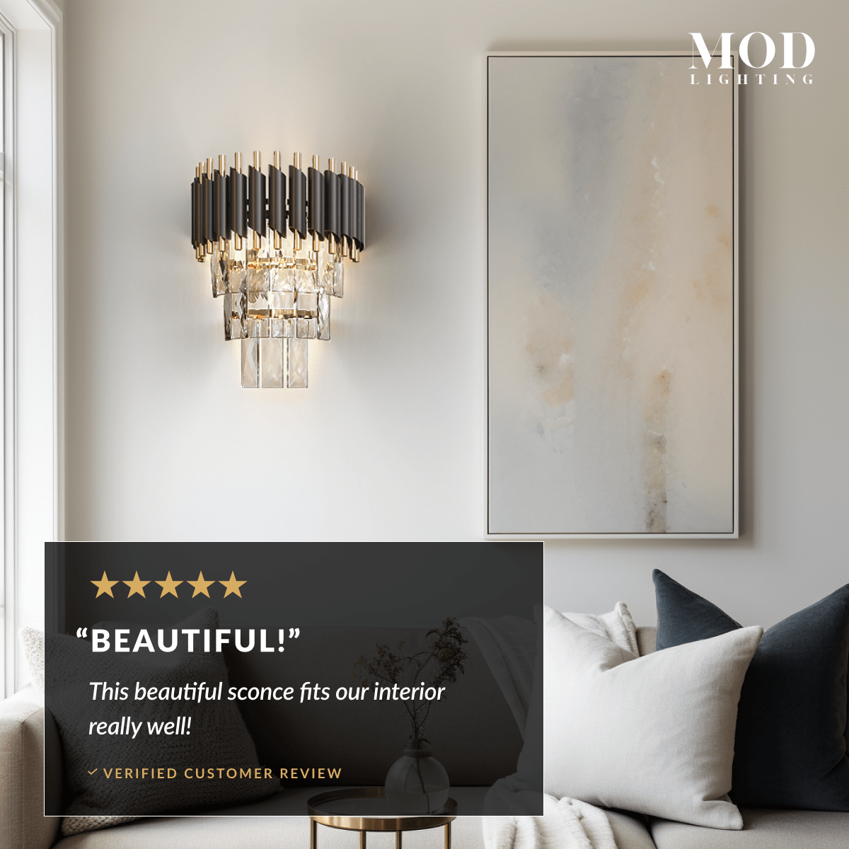 Onyx black and gold crystal wall sconce beside framed art above a bed with dark accent pillows