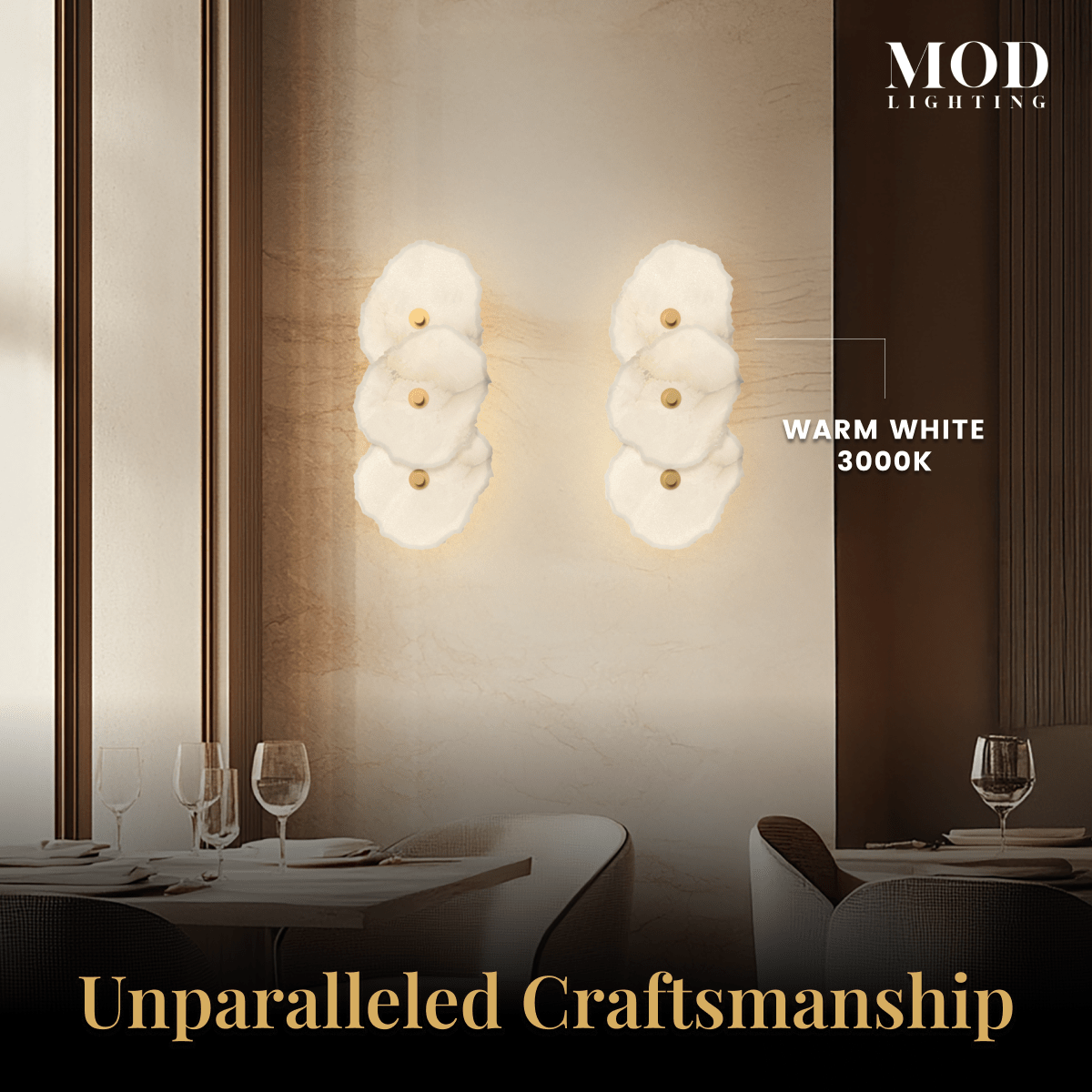 Alba Sconce pair, stacked alabaster-petal discs glowing warm white on a dining-room wall above set tables