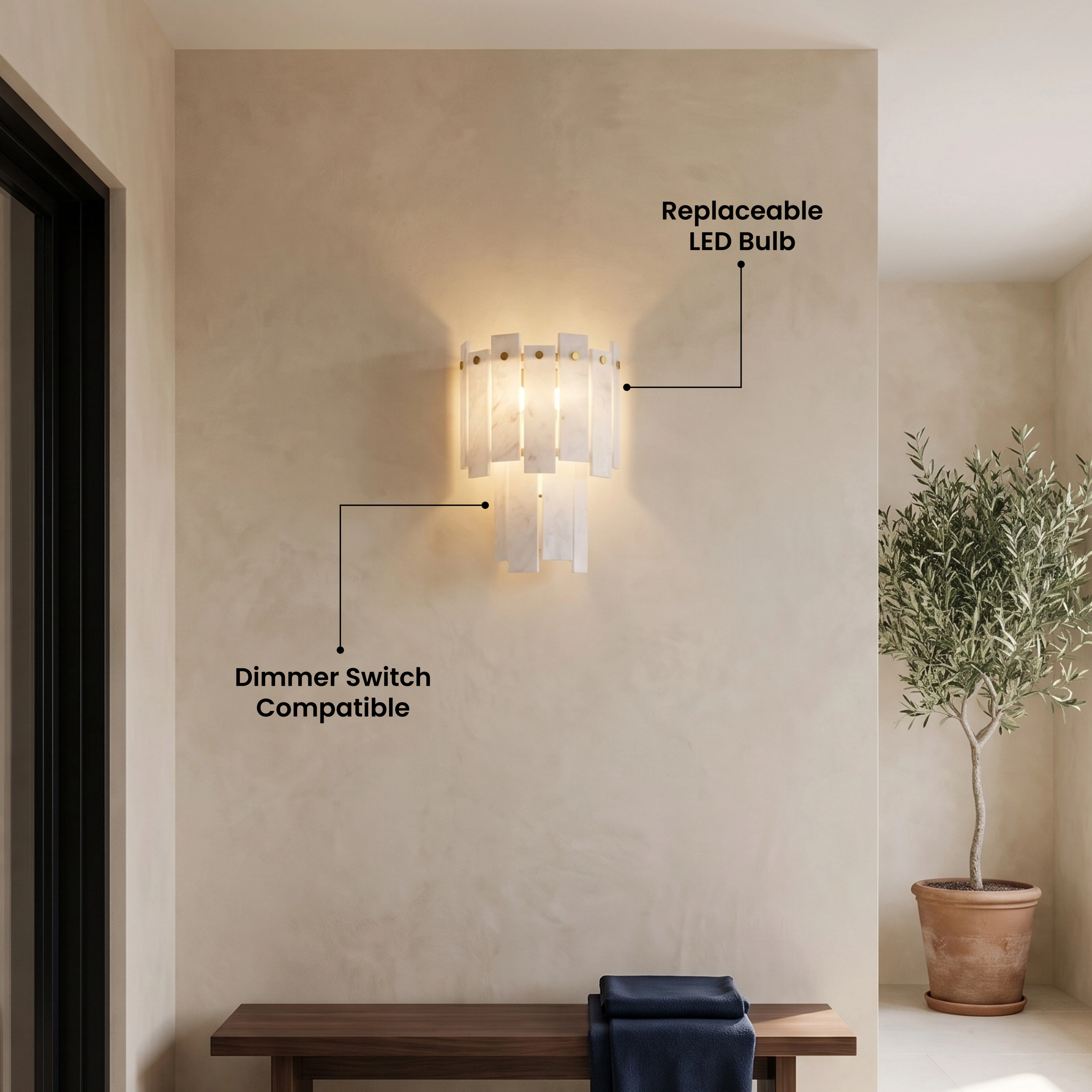 Velina Sconce gold wall light with tiered alabaster panels casting a warm glow on a tiled wall