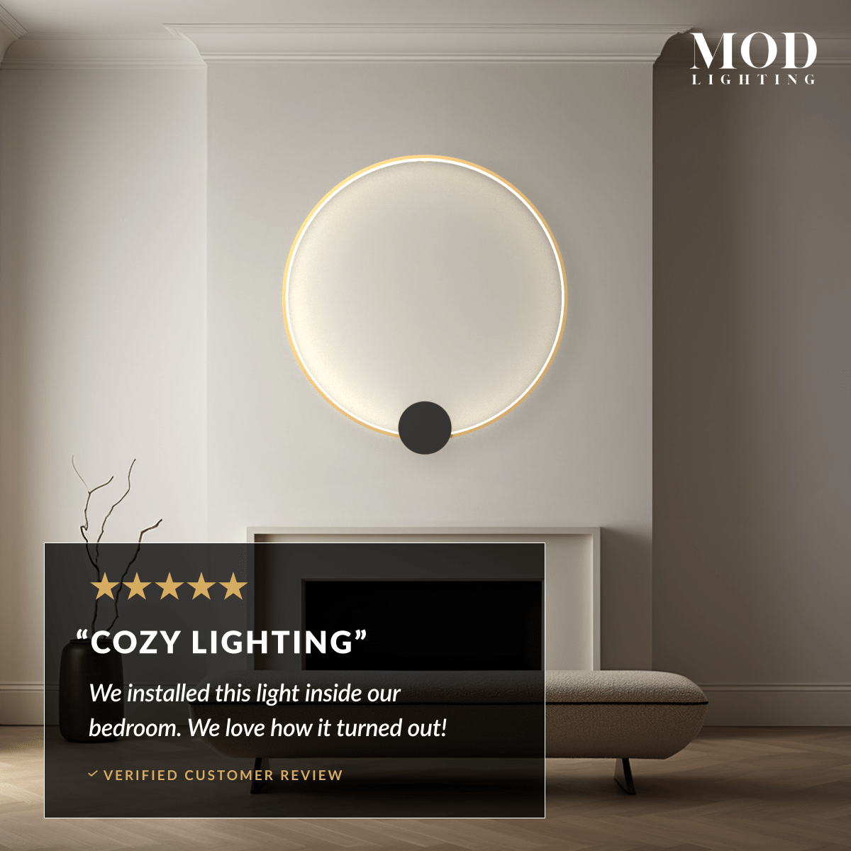 Halo gold ring wall lamp with black disc center, glowing above a fireplace in a neutral living room