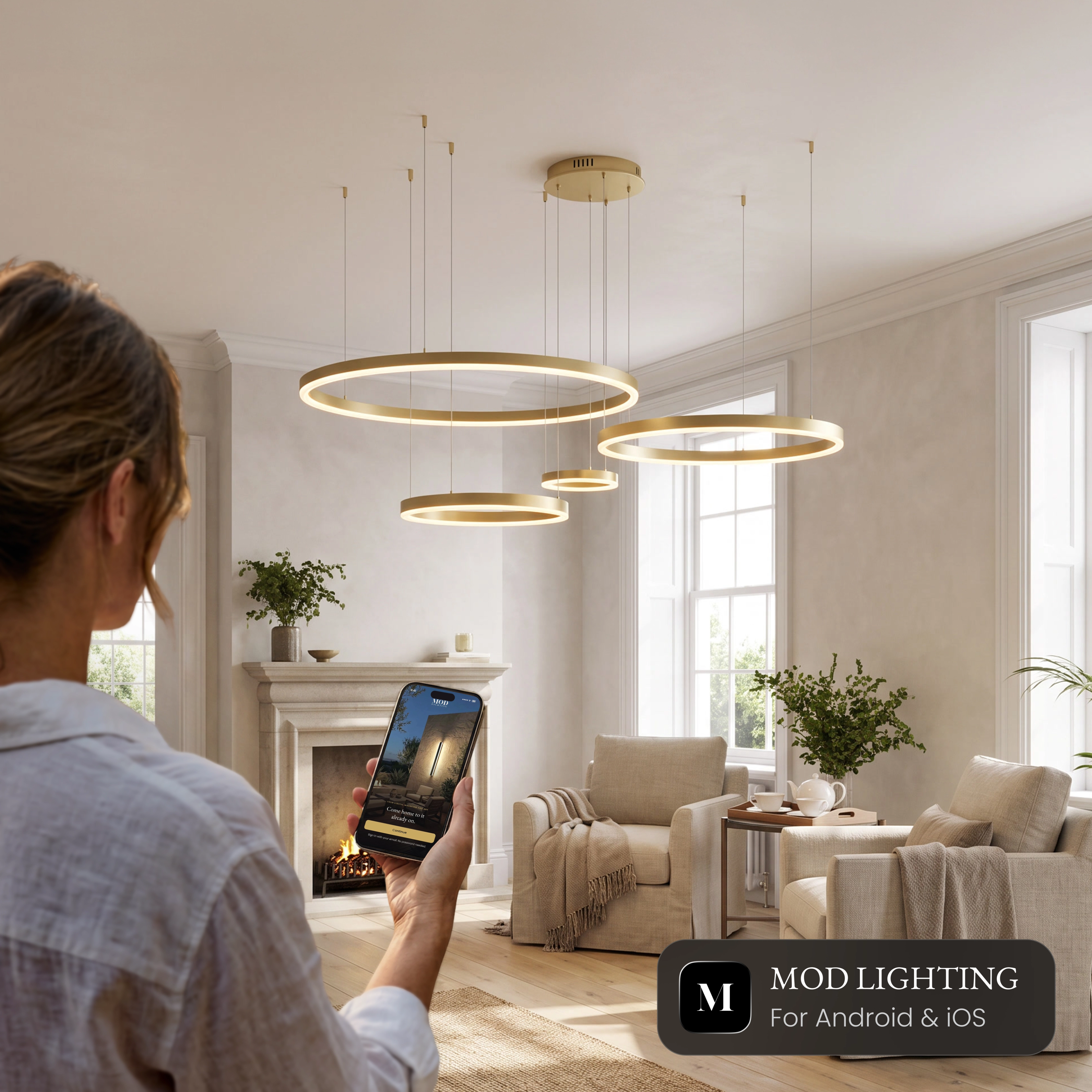 Charlotte Smart ring chandelier in a living room, controlled from the MOD LIGHTING app on a phone