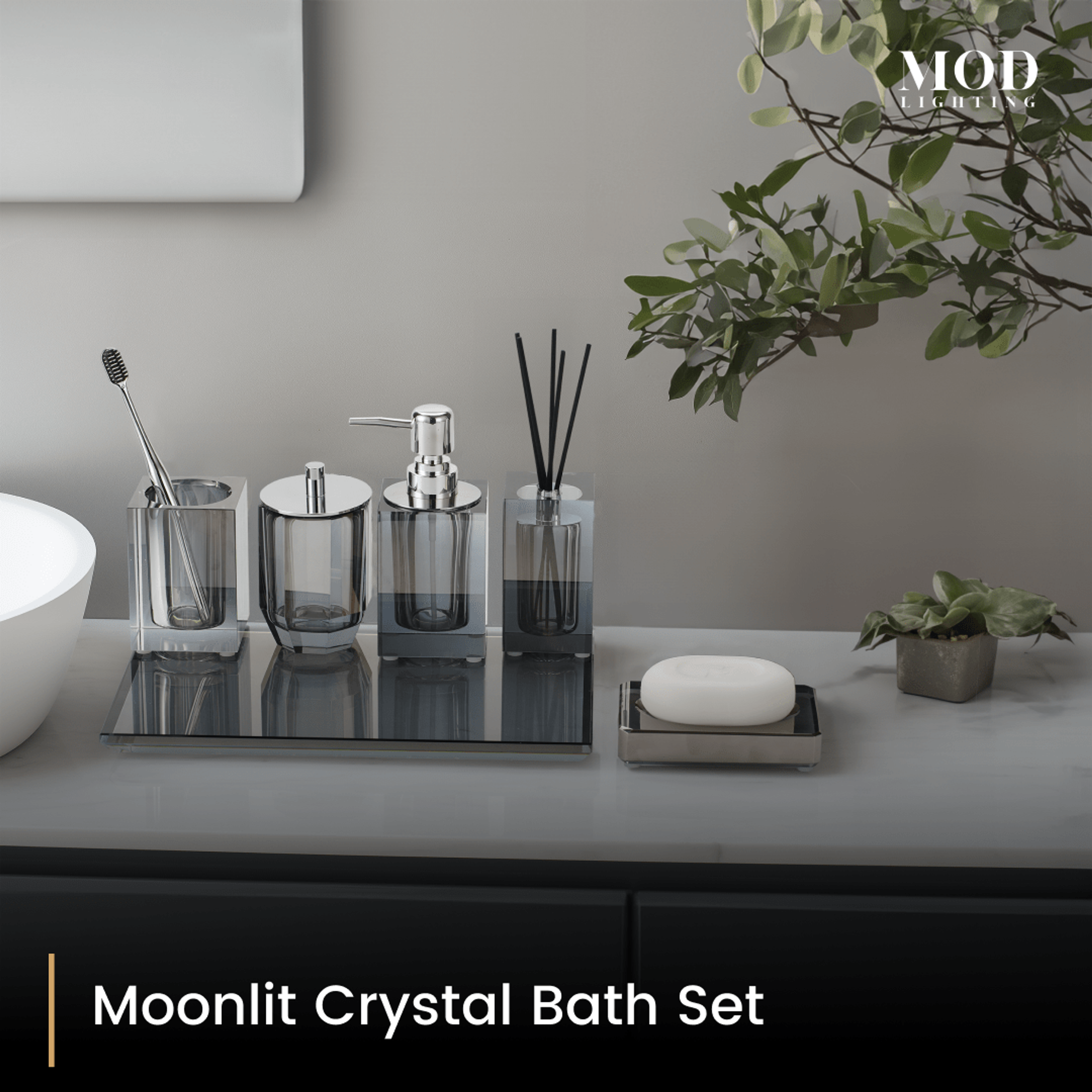Moonlit Crystal Bath Set, smoky grey crystal accessories on a mirrored tray beside a round basin and potted greenery
