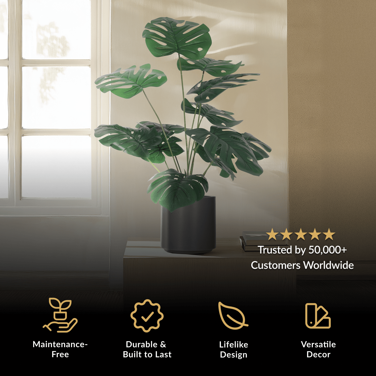 Monstera, artificial plant with split green leaves in a black cylindrical pot on a table