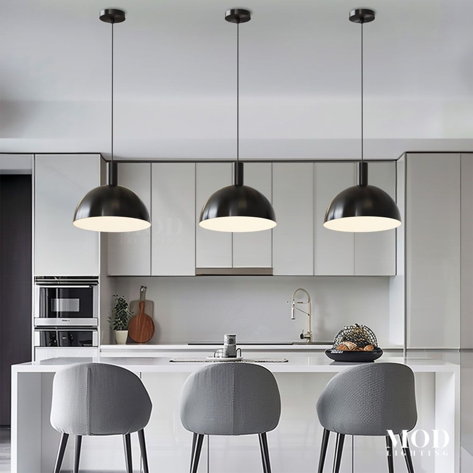 Kinsley pendant trio in matte black, dome shades suspended over a white kitchen island with grey bar stools