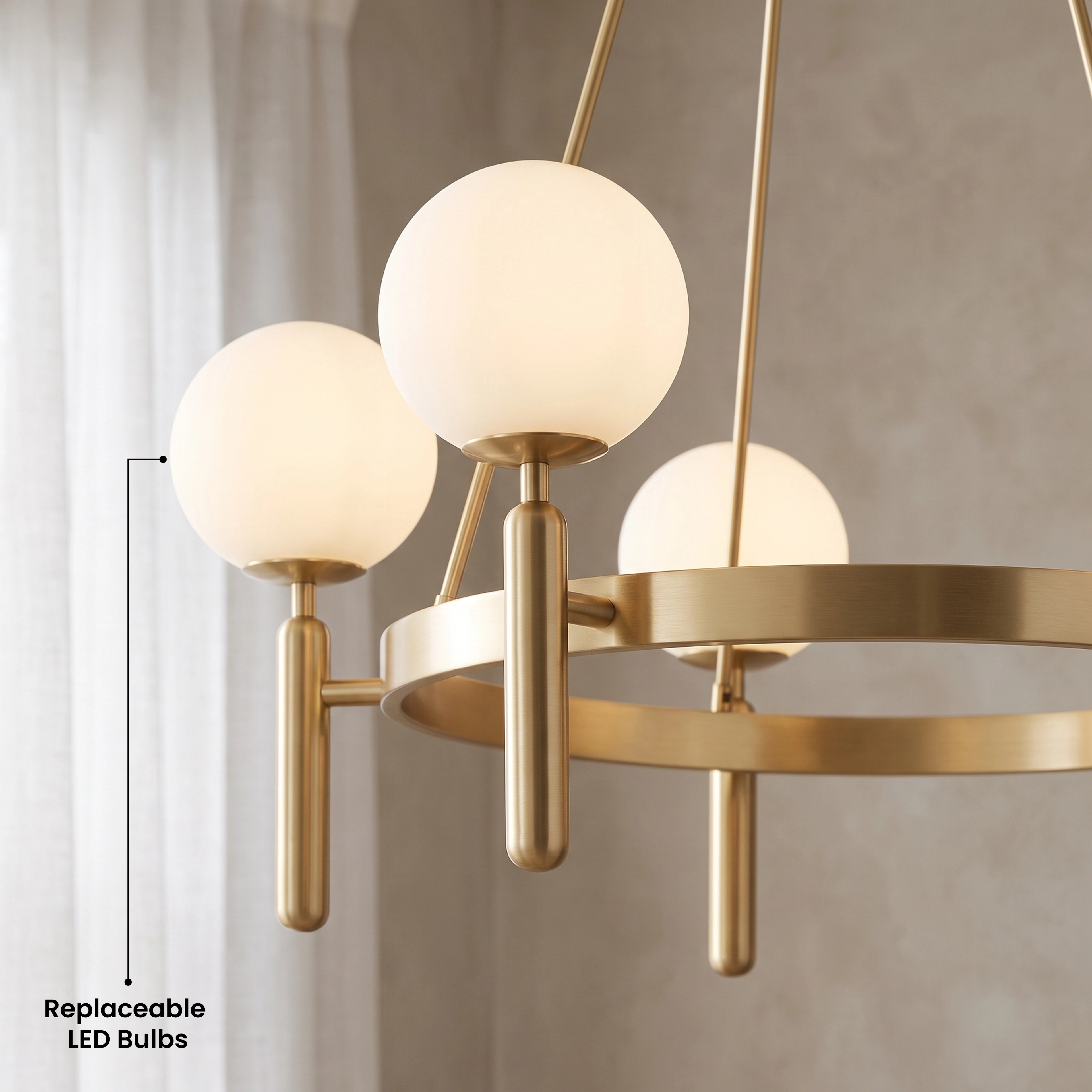 Angelica gold ring chandelier, six white opal-glass globes on a brass hoop, over a living-room sofa