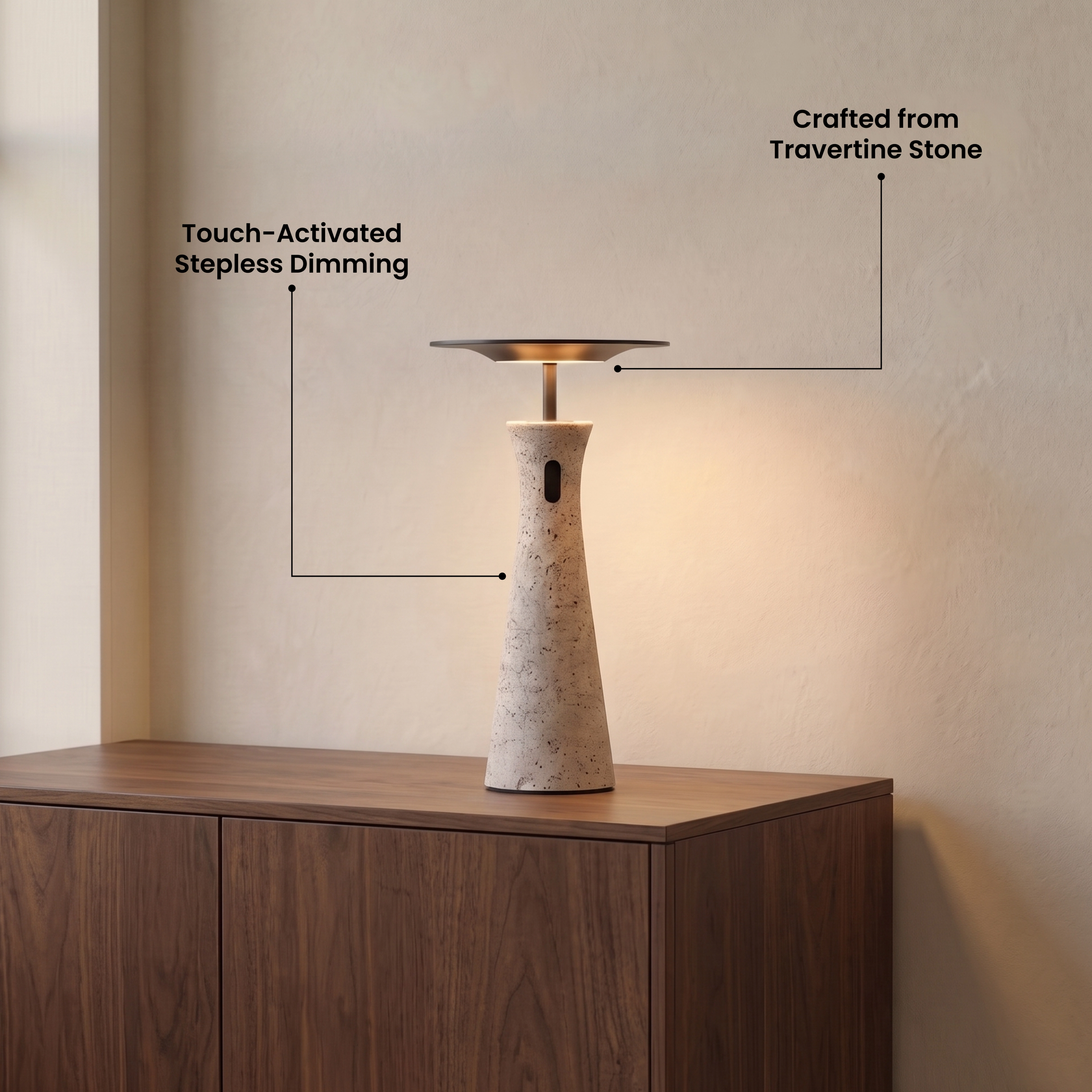 Dara tapered travertine table lamp with black disc shade beside a bed, glowing warm white