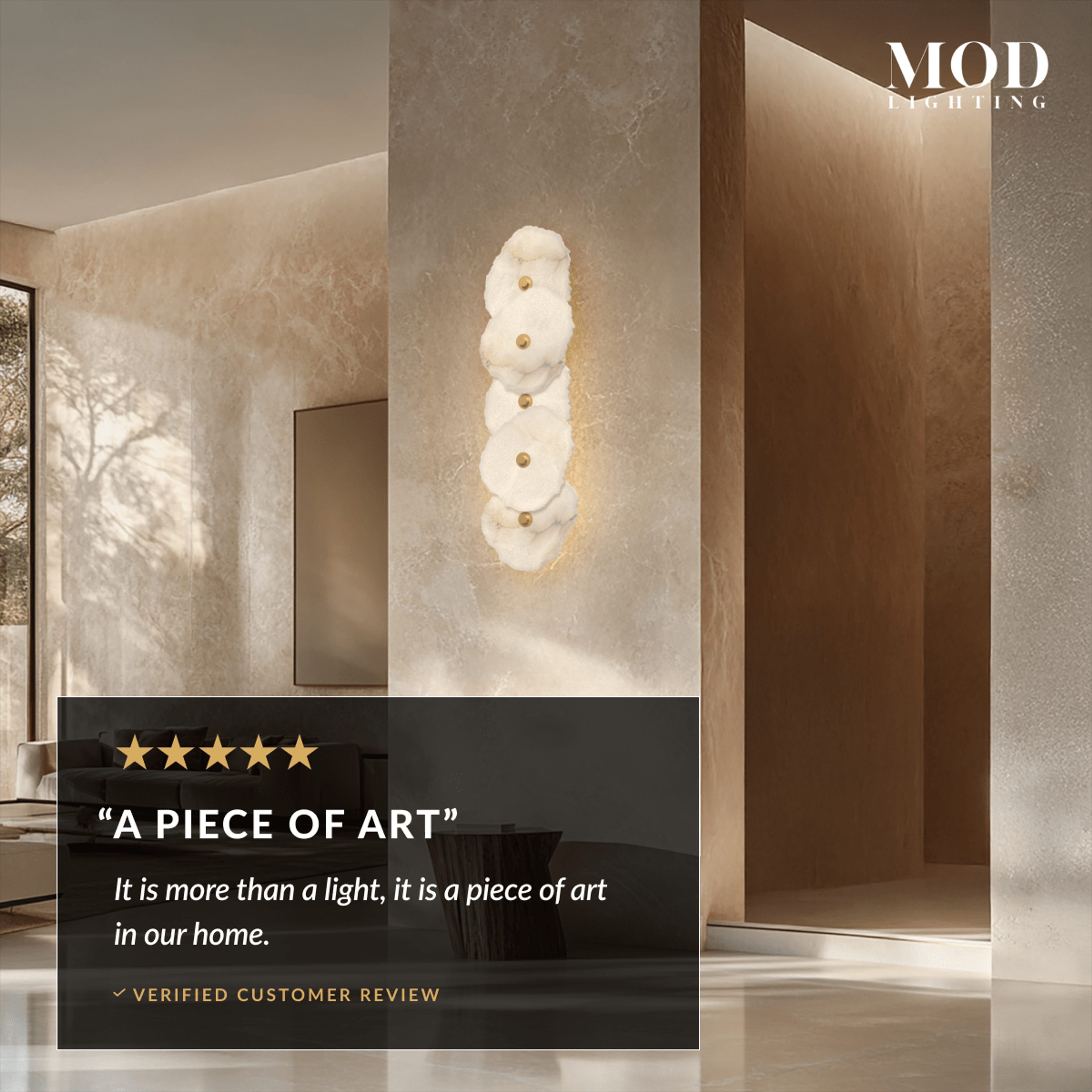 Alba Sconce, tall column of stacked alabaster-petal discs glowing on a stone-lined entryway wall