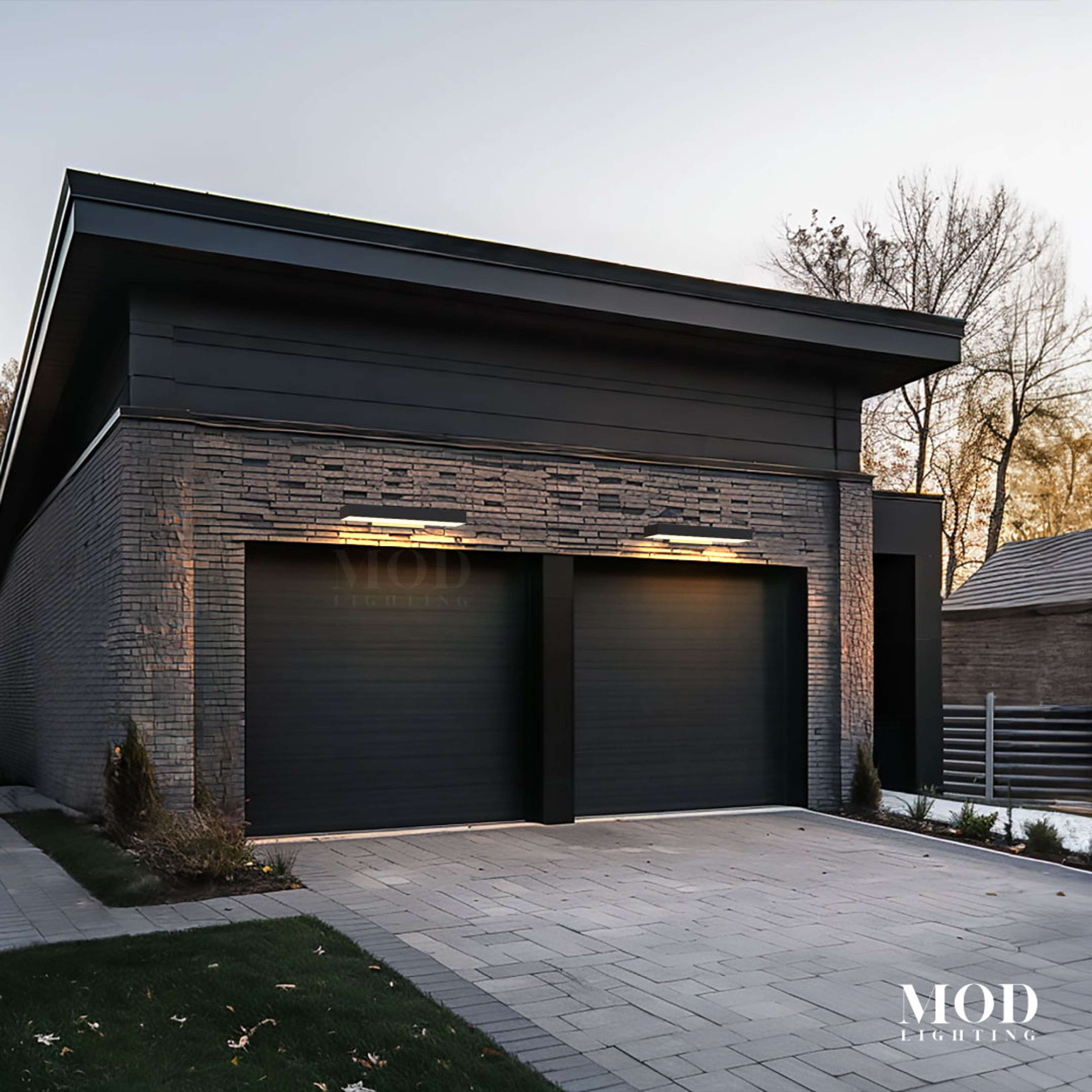 Brook black LED wall lights, two wide horizontal bars glowing above garage doors on a stone modern facade