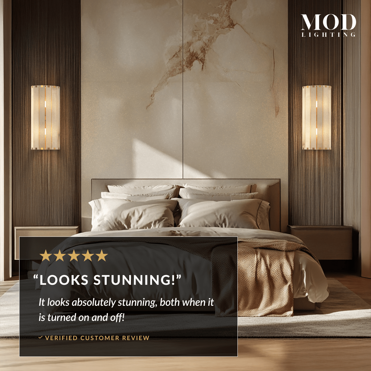 Two Nala alabaster wall sconces lit warm on either side of a bed with a marble headboard wall