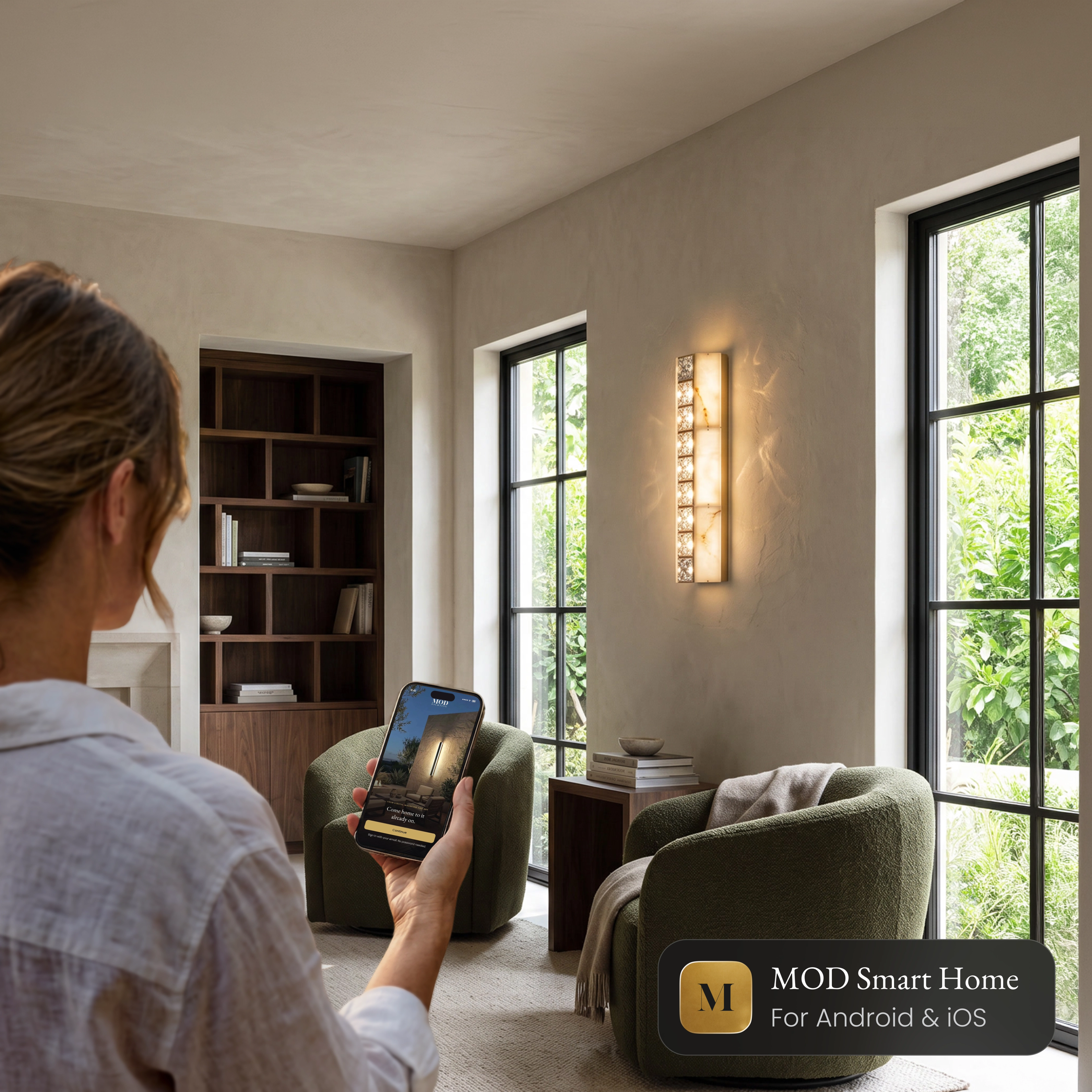 Seraphine Sconce Smart crystal wall sconce in a living room, controlled from the MOD Smart Home app on a phone